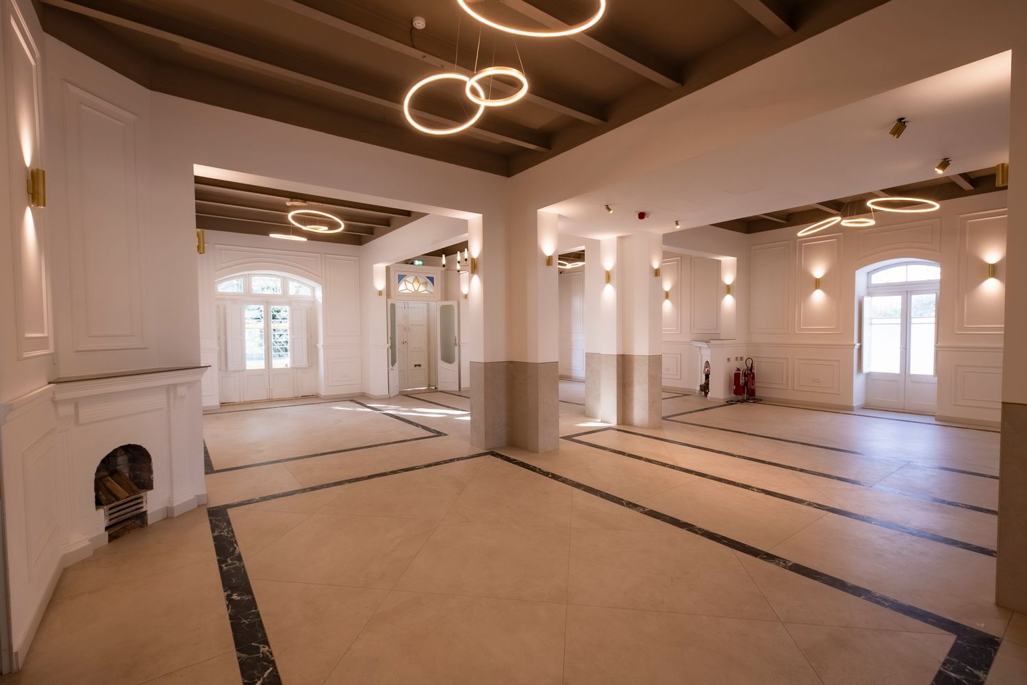 Spacious modern hall with circular pendant lights and polished floors.