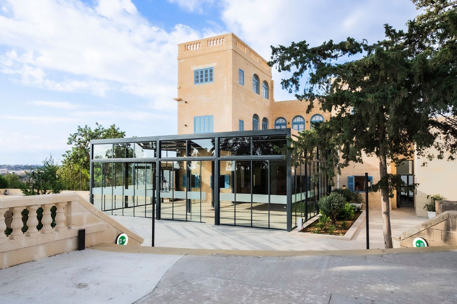 Panoramic view of a contemporary building terrace with stone architecture and glass panels.