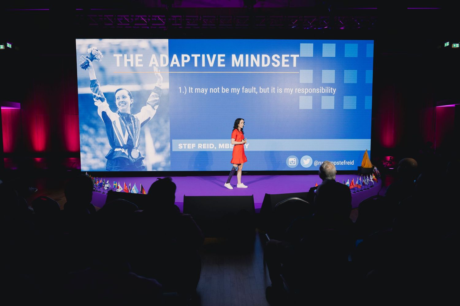 Large presentation screen displaying 'The Adaptive Mindset' at corporate event.