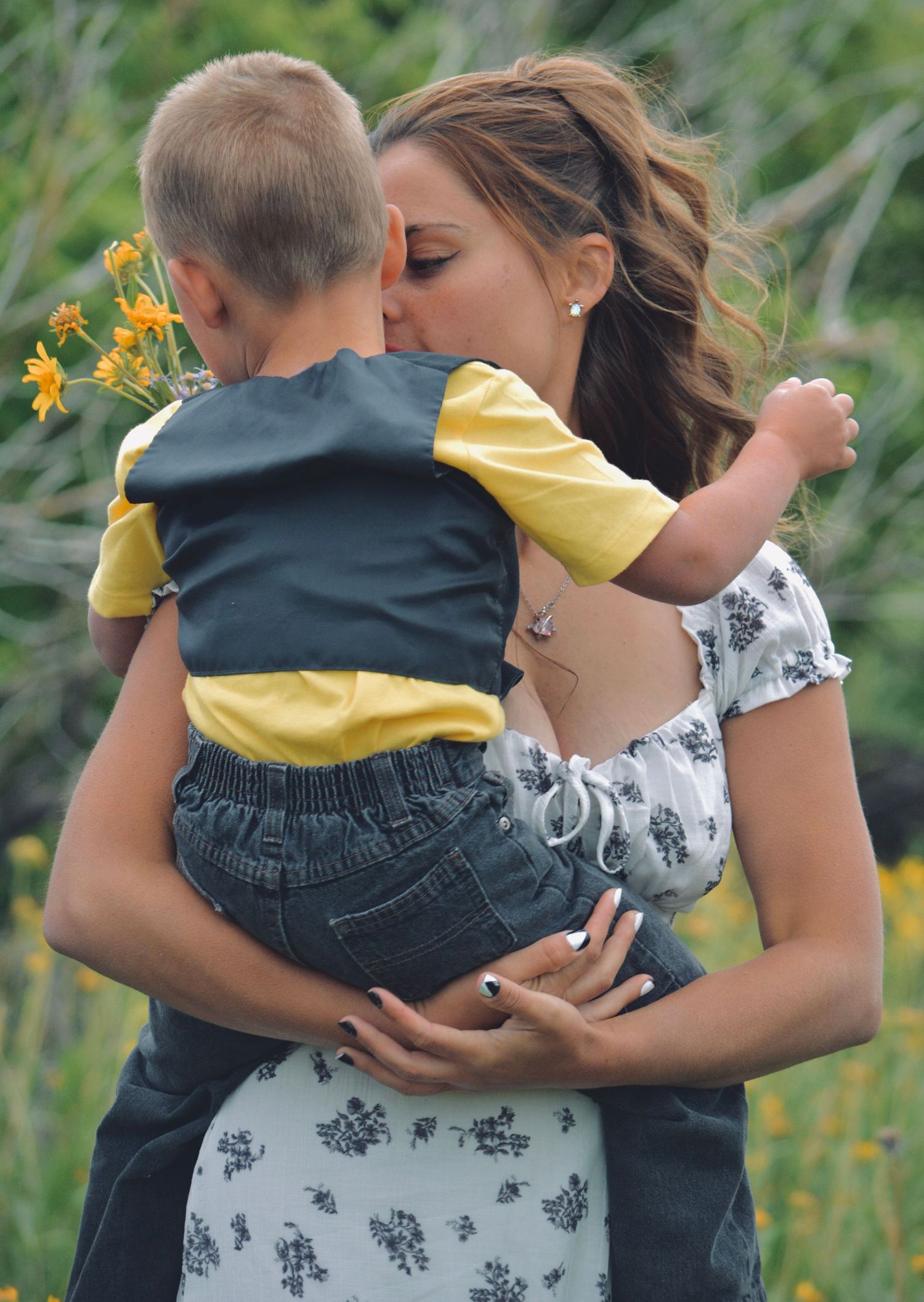 An intimate moment captured in a field of yellow wildflowers on a summer day.