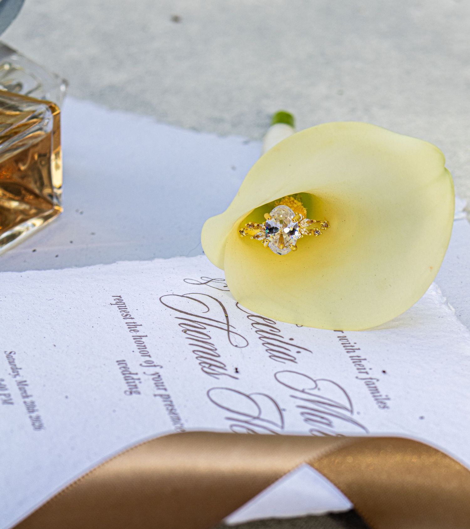 A pale yellow wax seal stamp being placed on an elegant wedding invitation with calligraphy text.