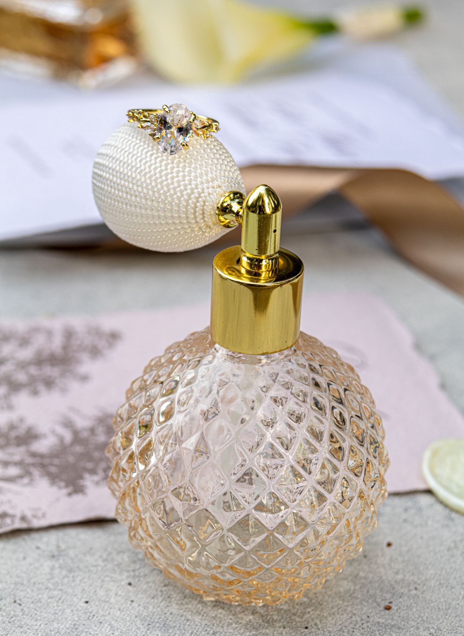 Vintage-style glass perfume bottle with diamond pattern and gold cap photographed from multiple angles on light surface.