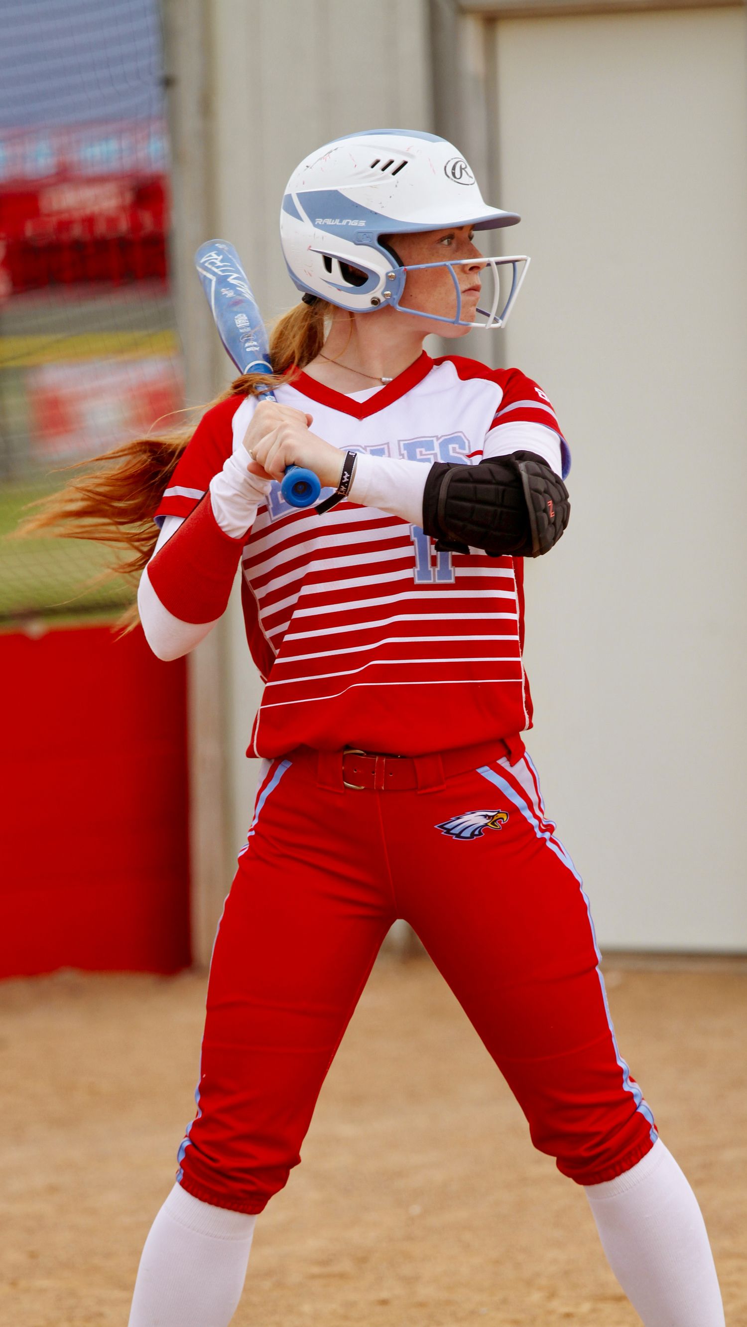 Softball batter in red and white uniform showing proper batting stance sequence.