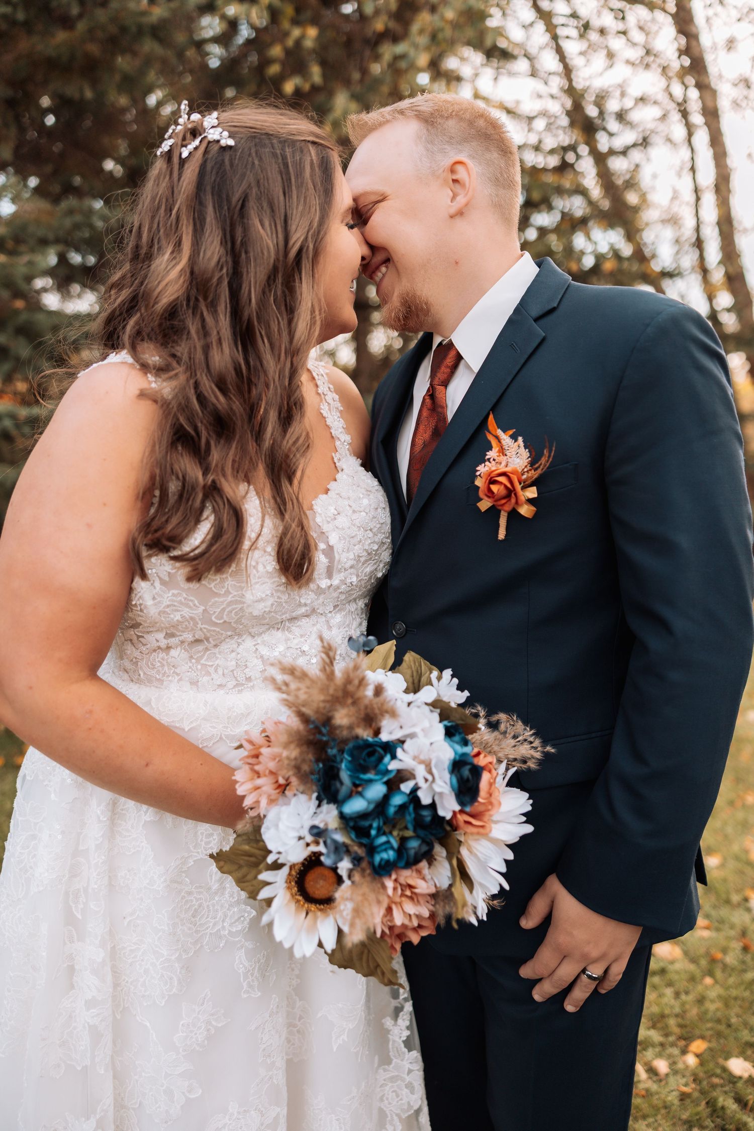 Intimate wedding couple moments captured with blue and orange floral bouquet details.