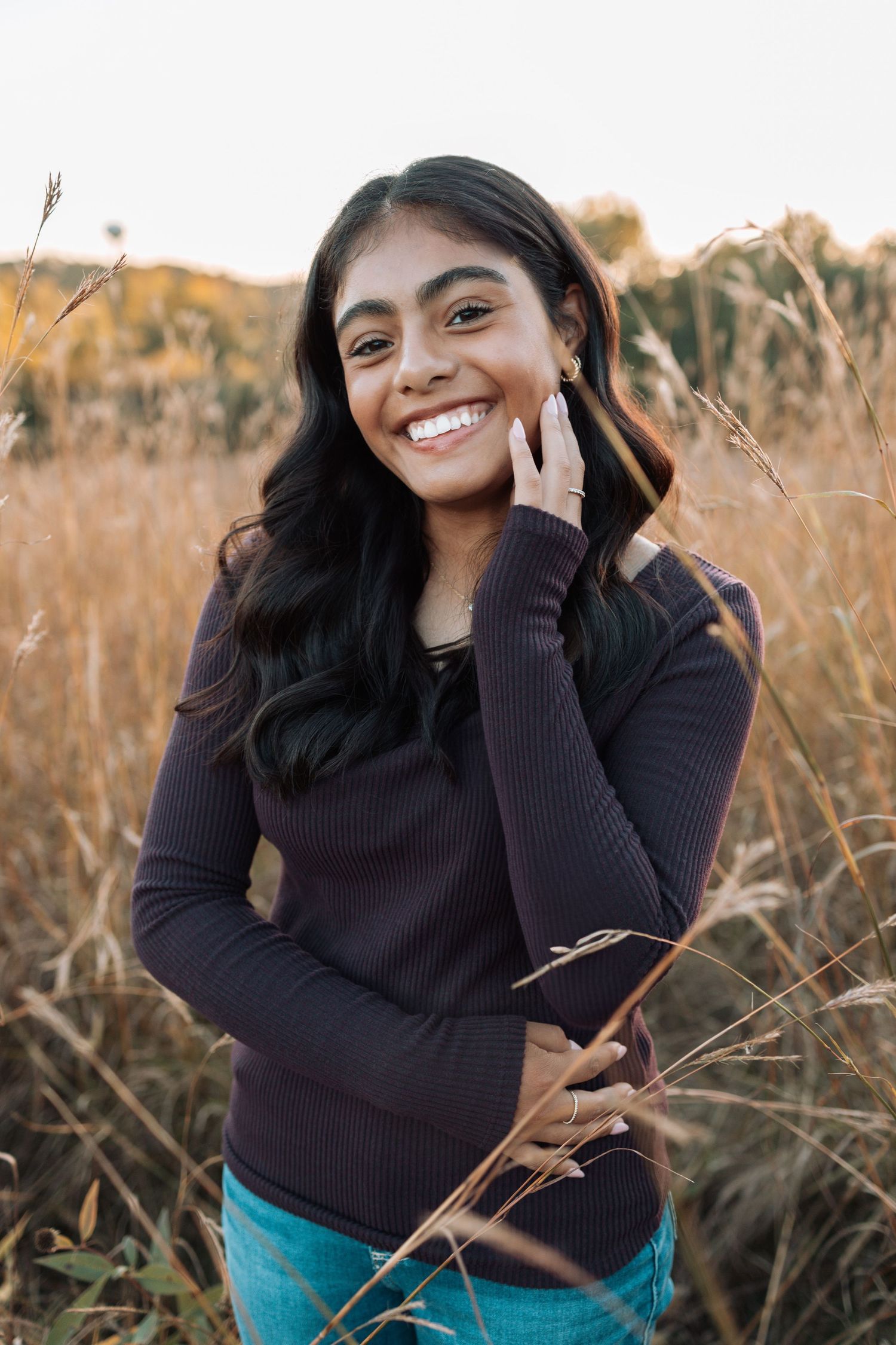 Woman in dark sweater smiles while standing in autumn field with Kenzie Ayla Images in the Twin Cities MN area.