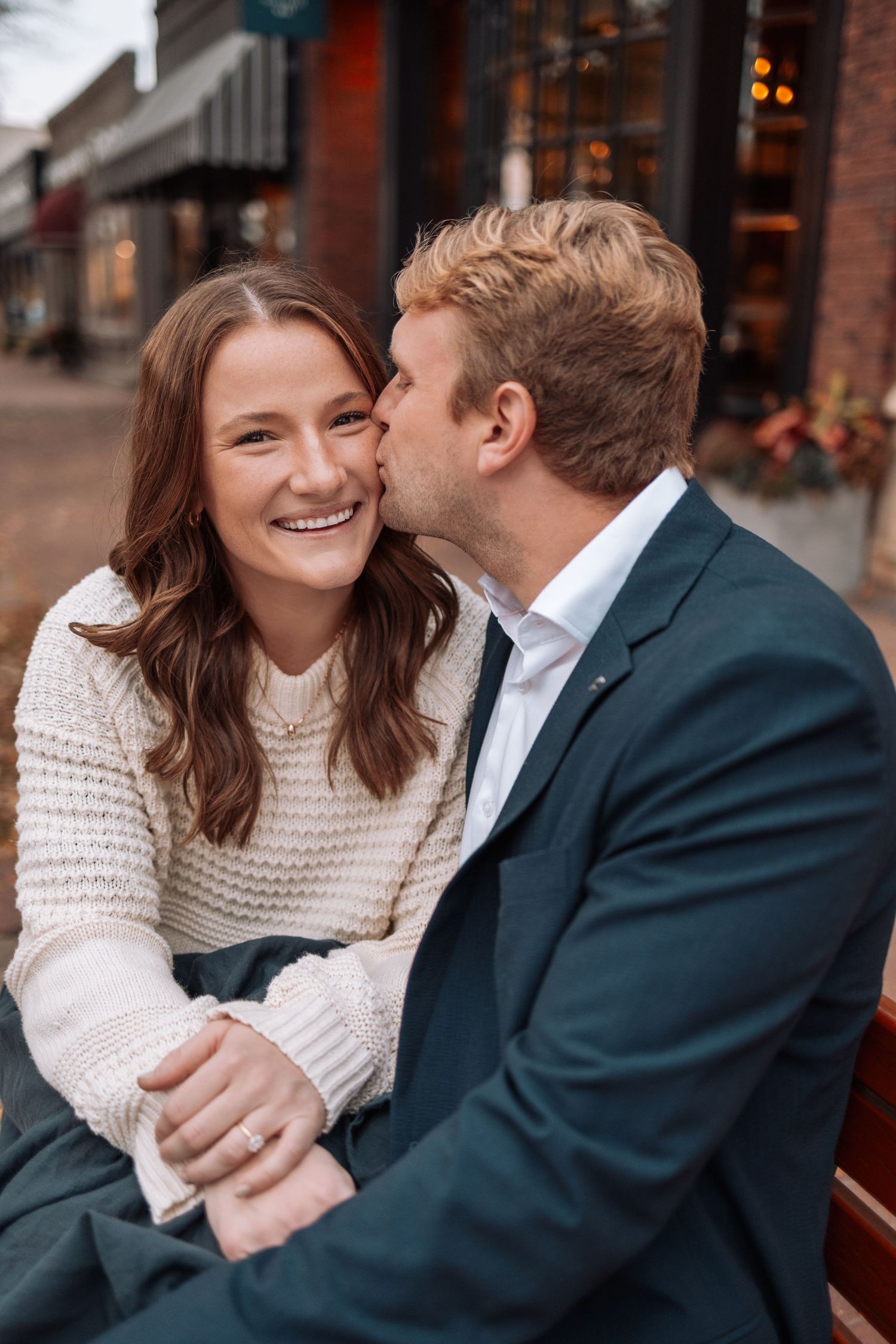 Couple sharing laughs while sitting at outdoor cafe.