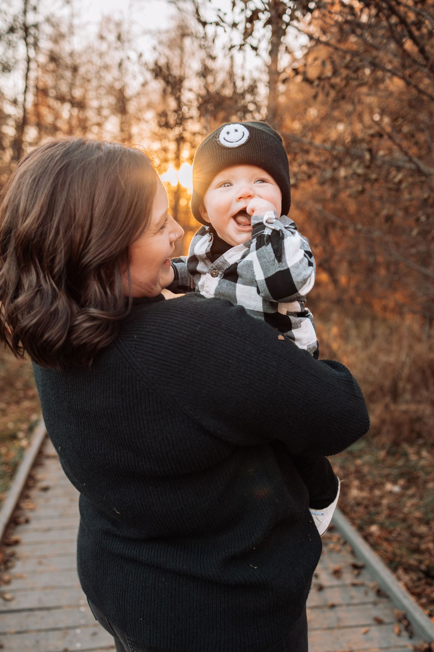 Autumn outdoor scene of two people hugging while wearing cozy sweaters.