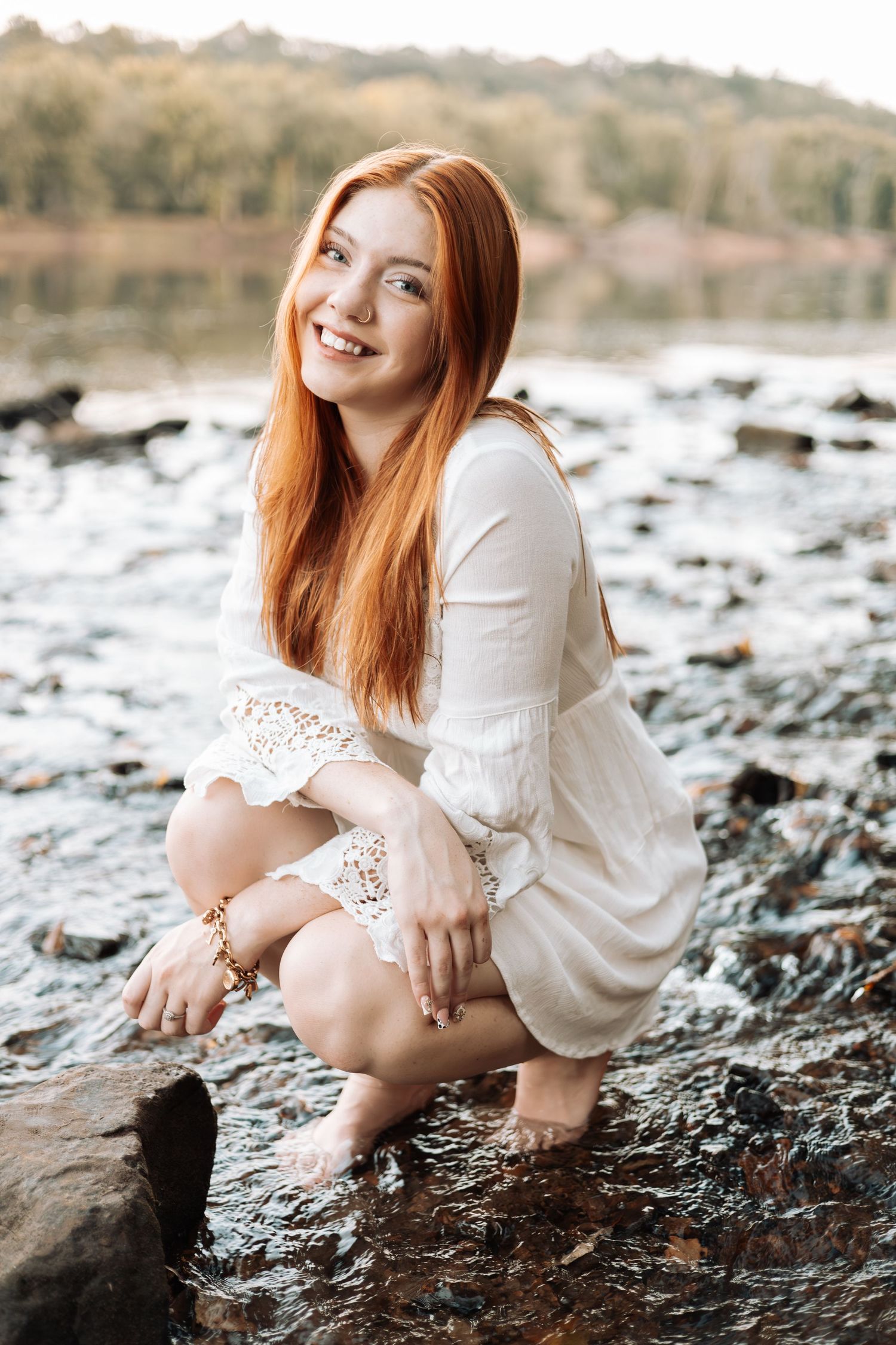 Portrait in white lace dress posed on rocky riverbank with Kenzie Ayla Images in the Twin Cities MN area.