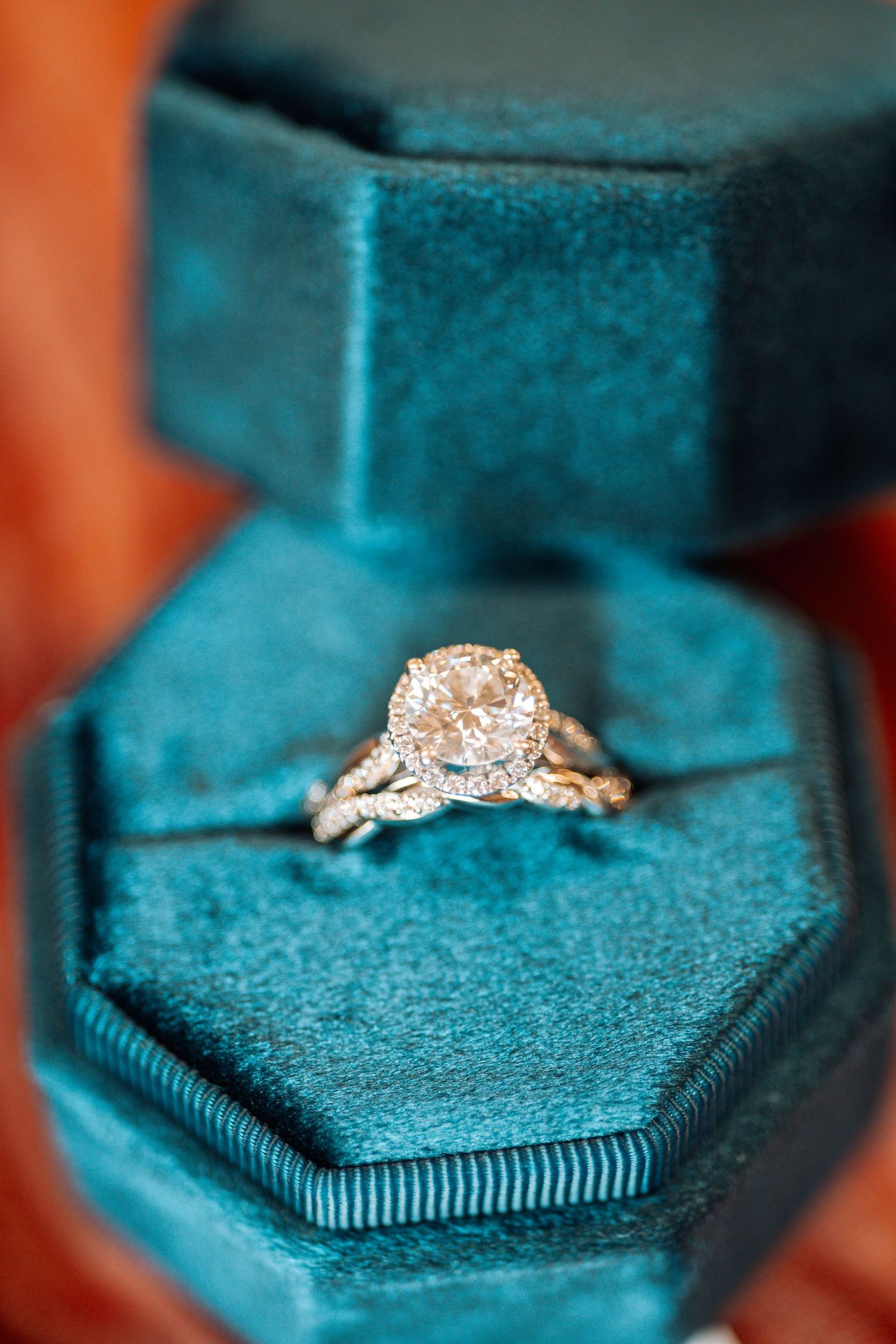 Sparkling diamond engagement ring in teal velvet hexagonal ring box.