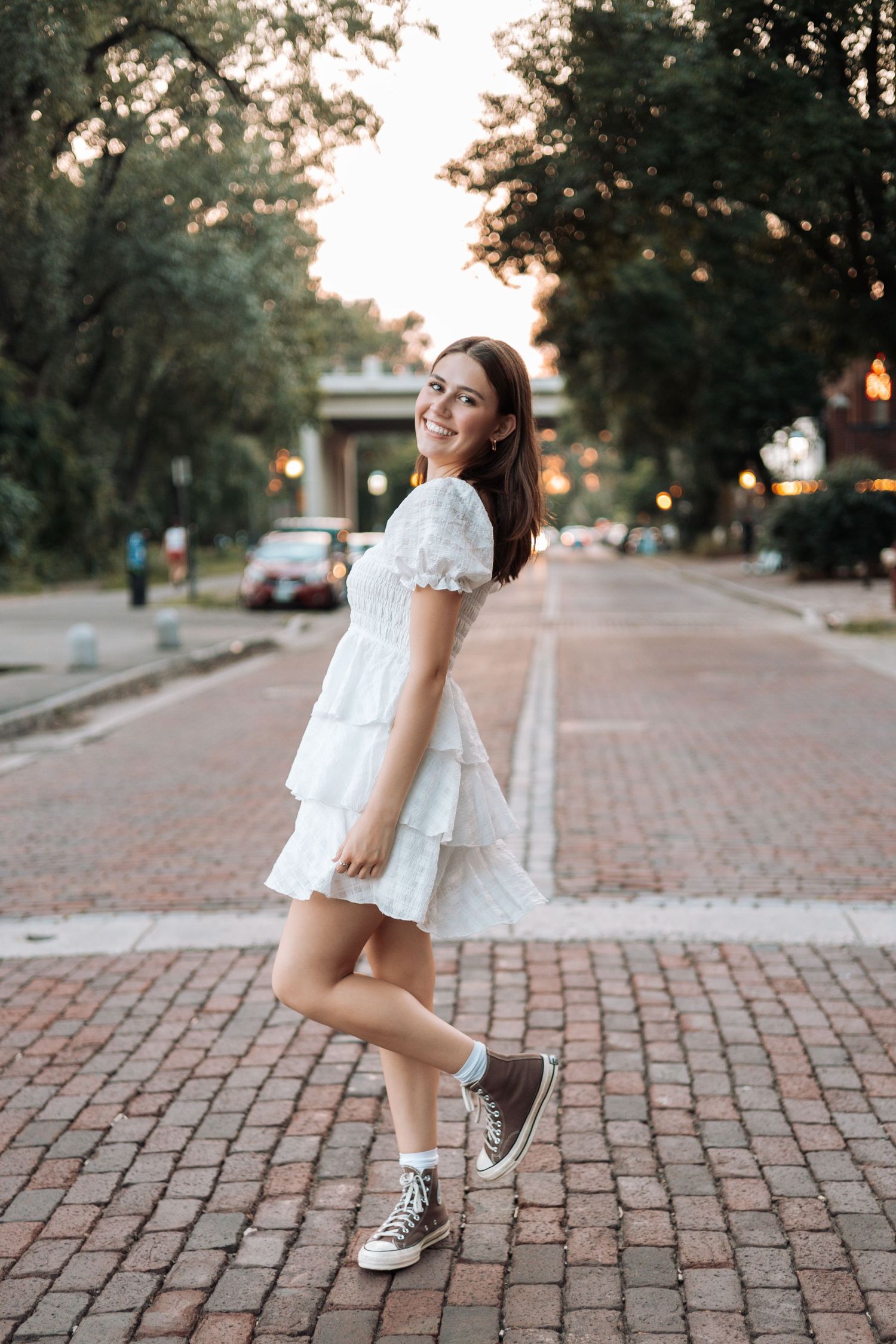 White summer dress and sneakers on brick paved street at sunset with Kenzie Ayla Images in the Twin Cities MN area.