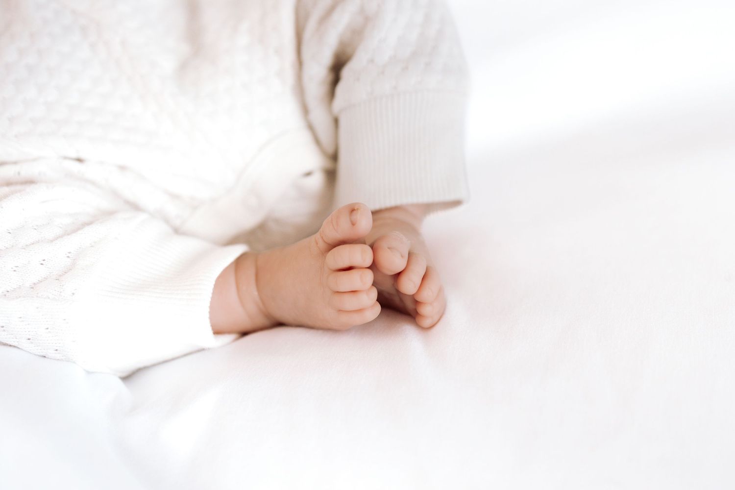 Minimalist white maternity photography session with soft natural lighting.