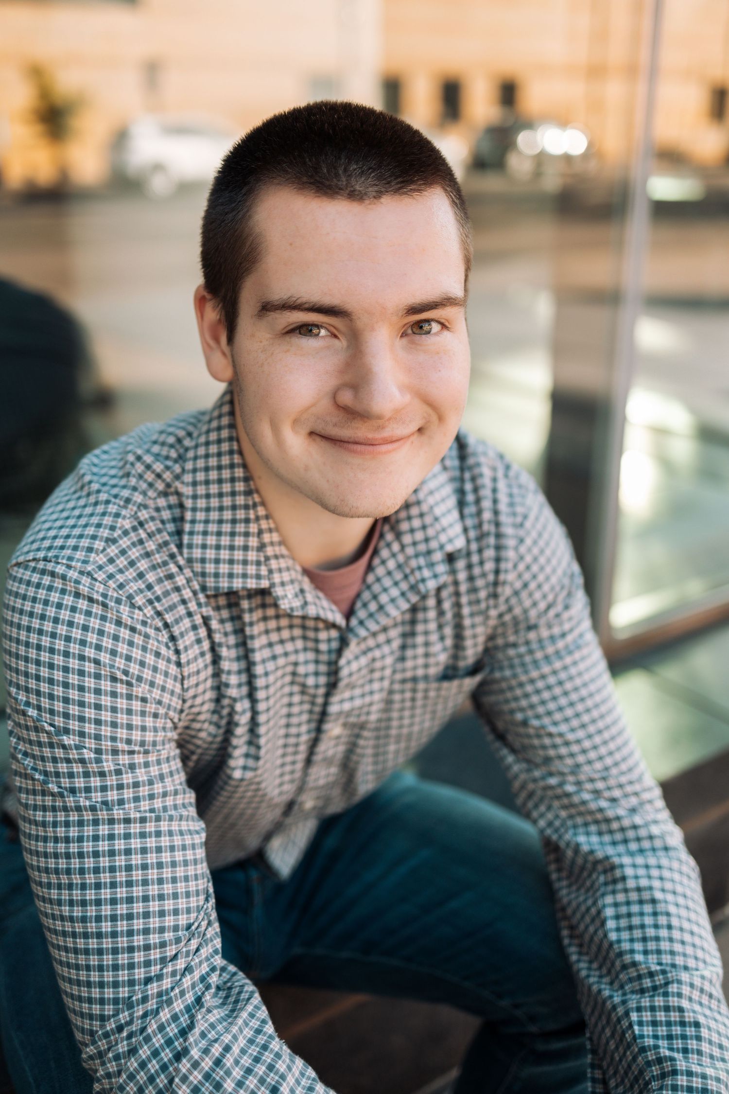 Professional portrait series showing warm expressions in a checkered button-down shirt against a blurred interior background.