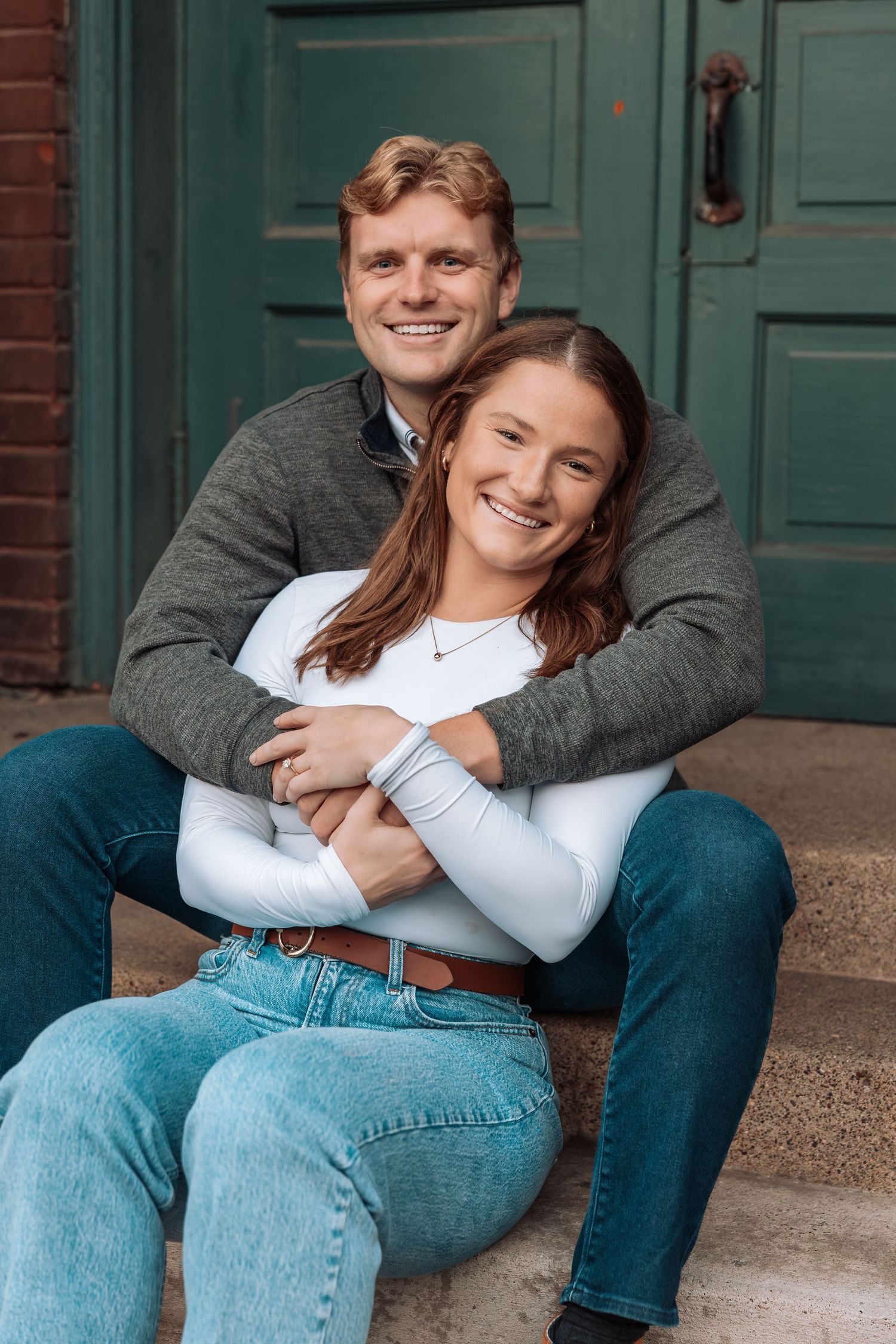Couple sitting on brick steps sharing tender moments together.