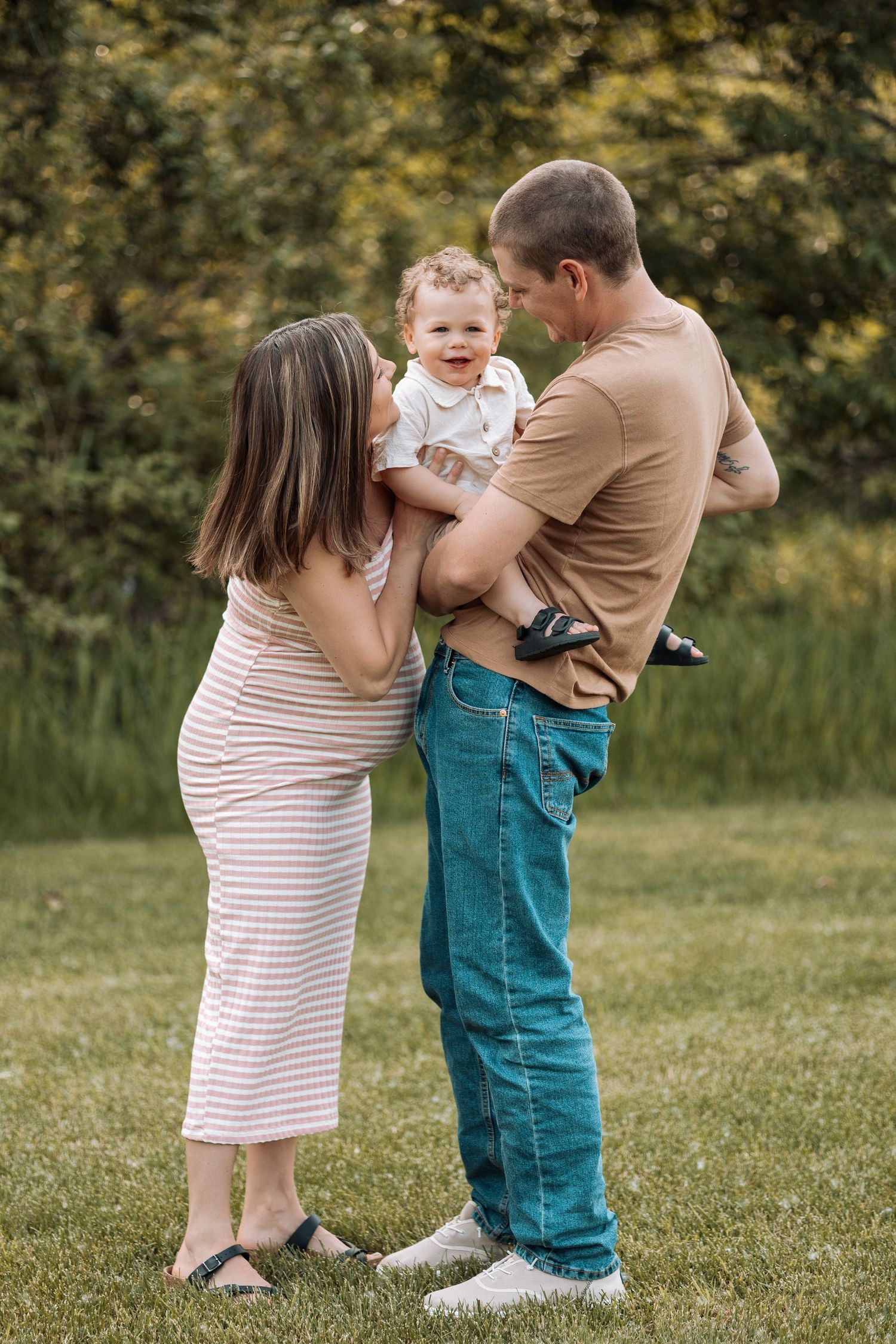 Two young children playing together outdoors on green grass wearing casual summer clothes.