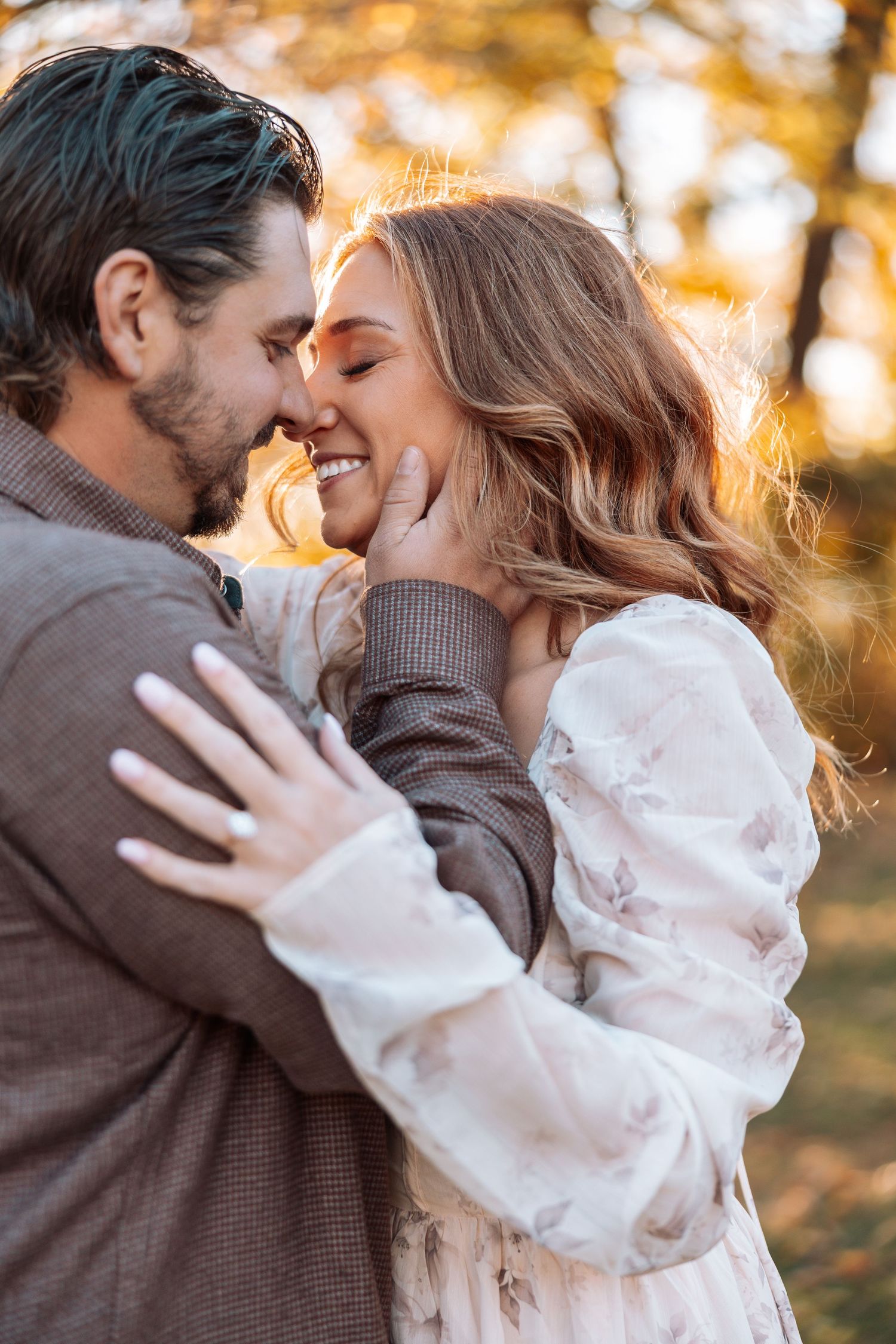 Romantic couple sharing intimate moments in golden autumn sunlight.