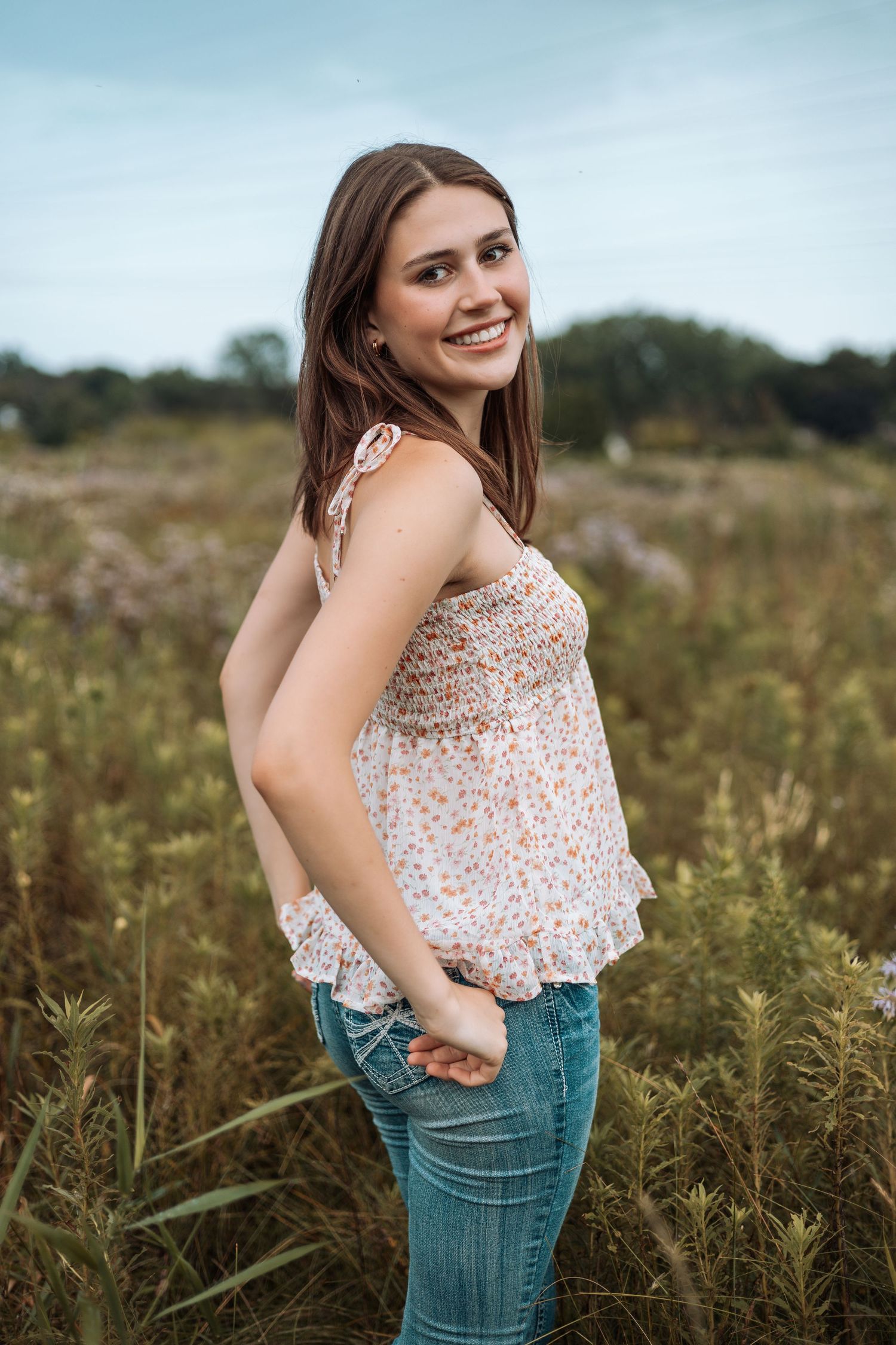 Floral top and overalls outfit photographed in tall grass field at sunset with Kenzie Ayla Images in the Twin Cities MN area.