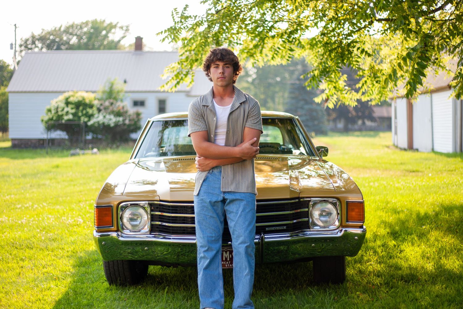 Classic vintage cars displayed on grass during sunny outdoor car show.