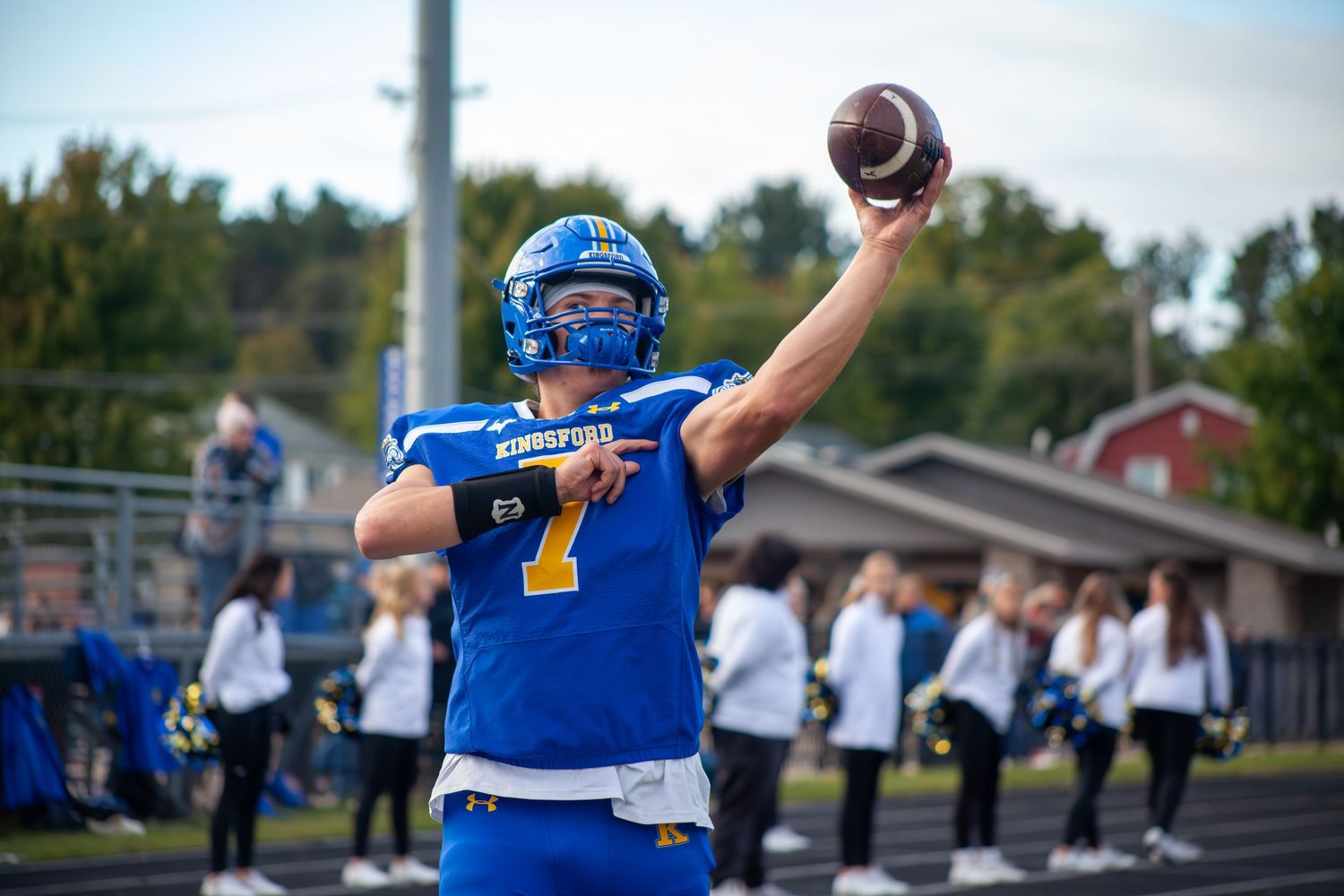Football player in blue jersey throws the ball during a game.