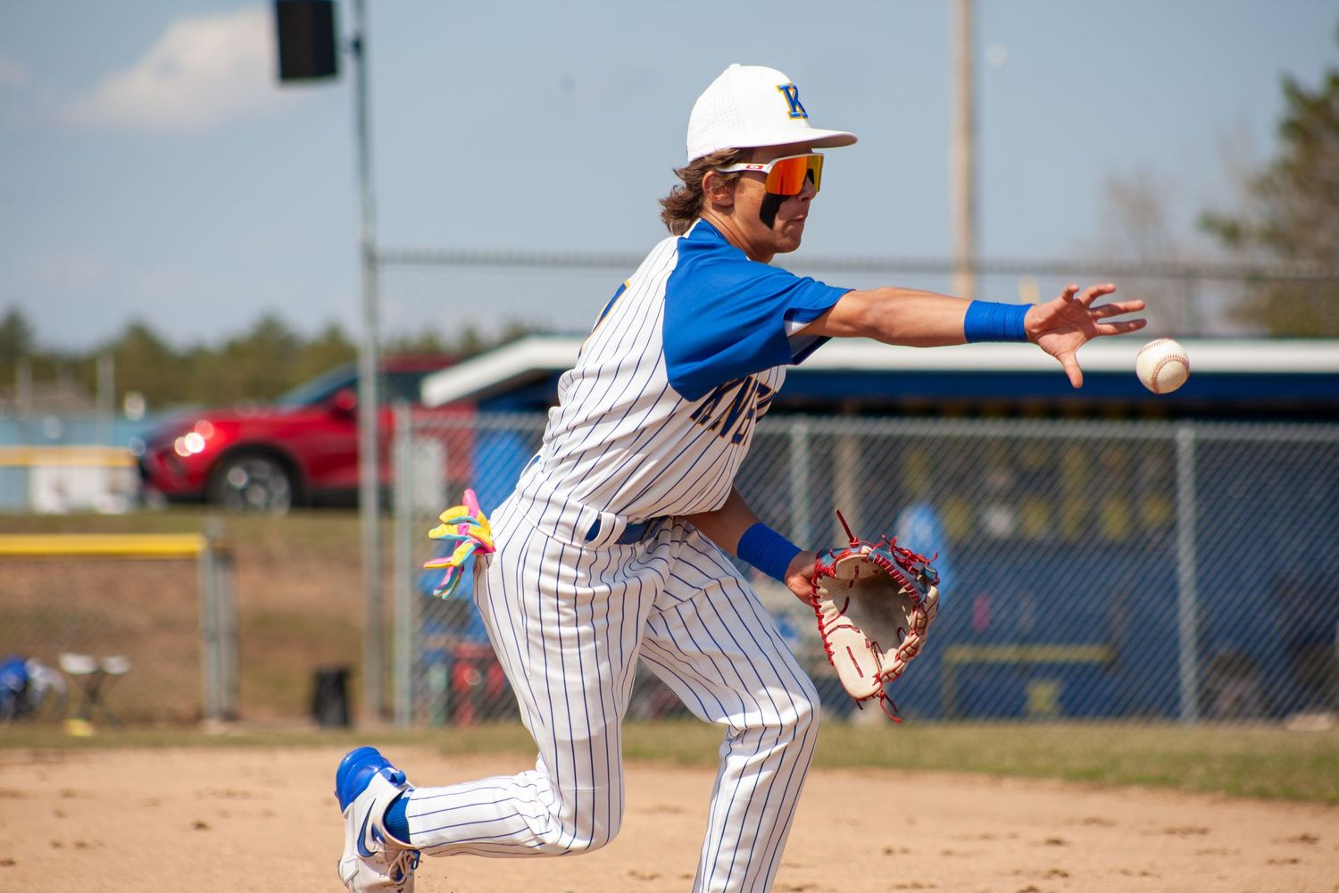 Baseball players in pinstriped uniforms making plays during competitive game.