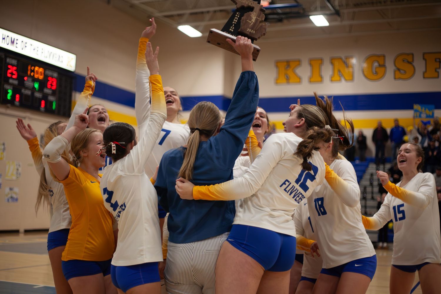 Indoor volleyball players celebrating points with raised arms and excited reactions.