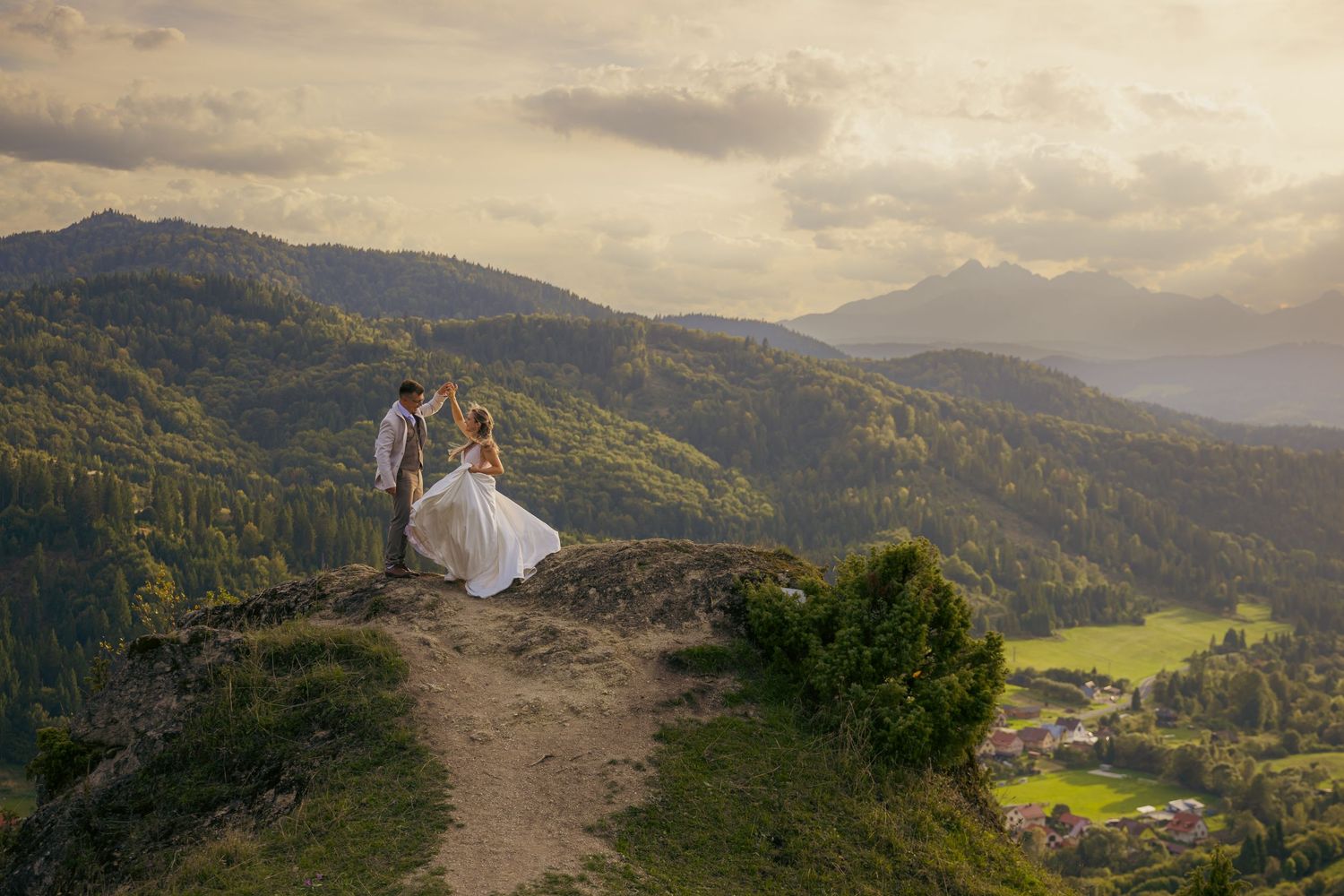 A scenic mountain vista with rolling hills and dramatic clouds at sunset.