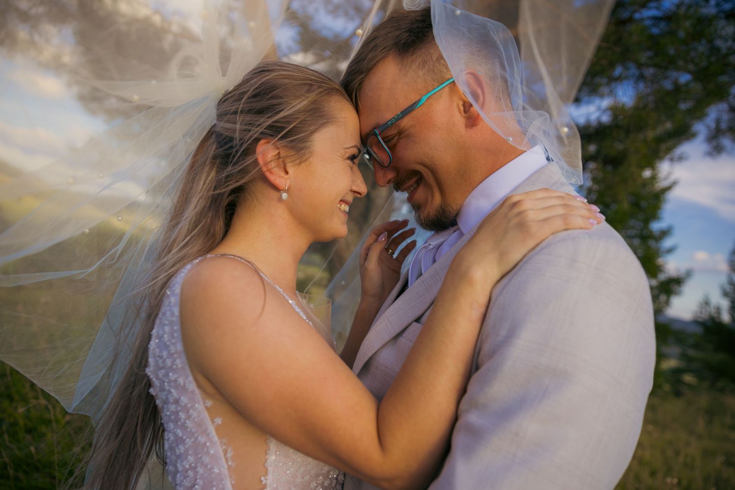 Romantic couple embracing under wooden gazebo at sunset.