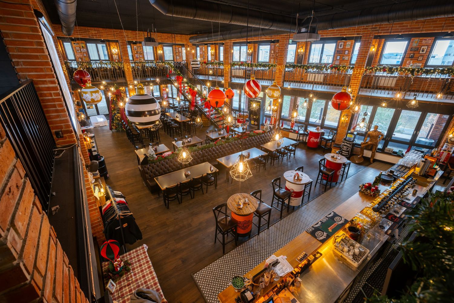 Rustic restaurant dining room with wooden beams and large windows overlooking a scenic view.