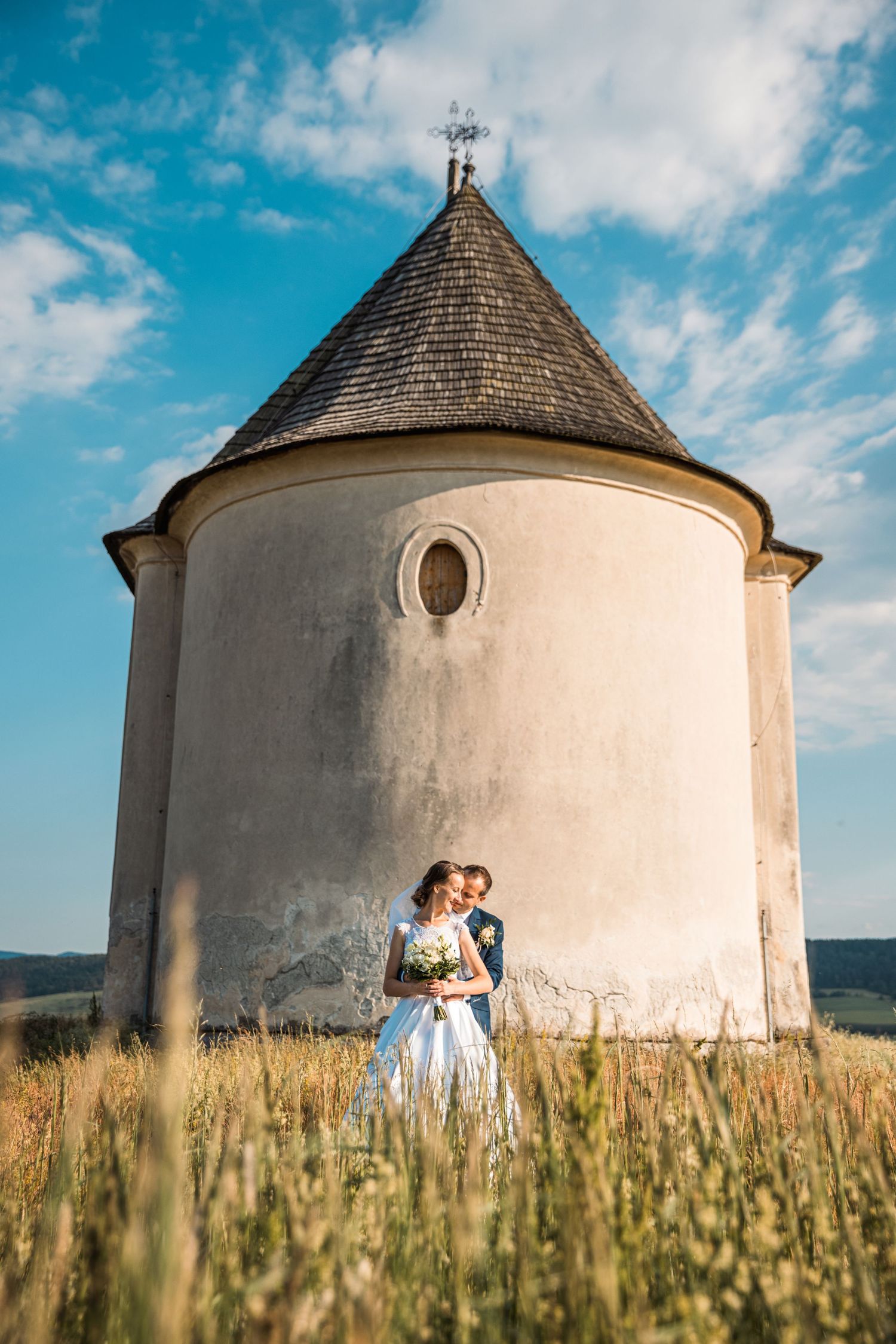 Historic white round towers in a field of tall grass under blue summer sky.