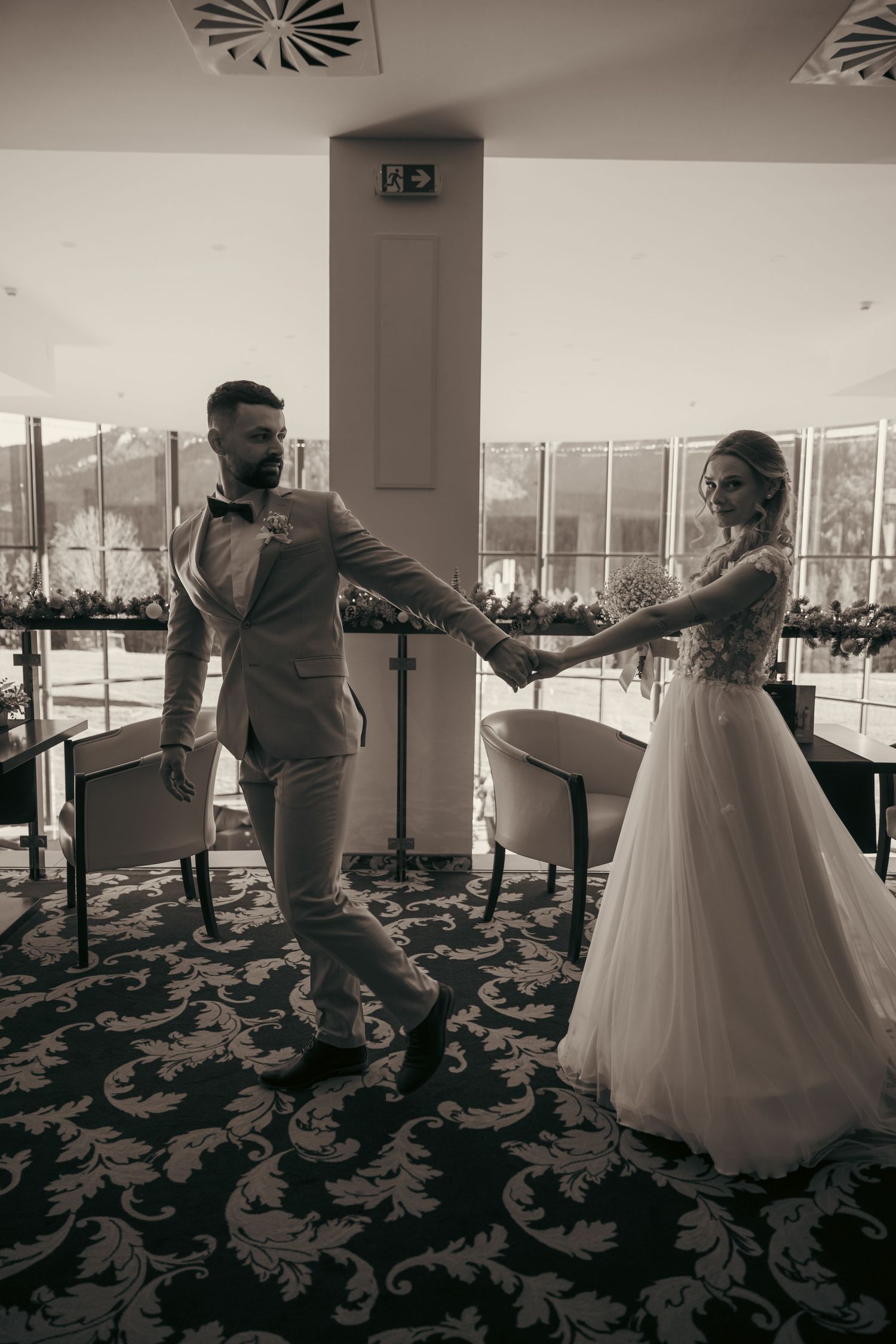 A series of black and white photos showing a couple dancing in a ballroom with a white wedding dress.
