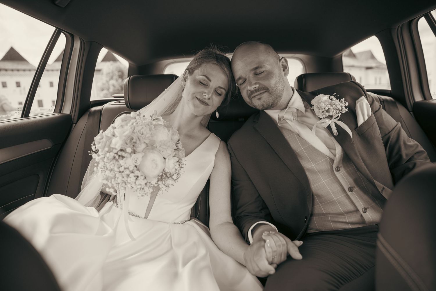 Black and white photo series of newlyweds sharing tender moments in car backseat.
