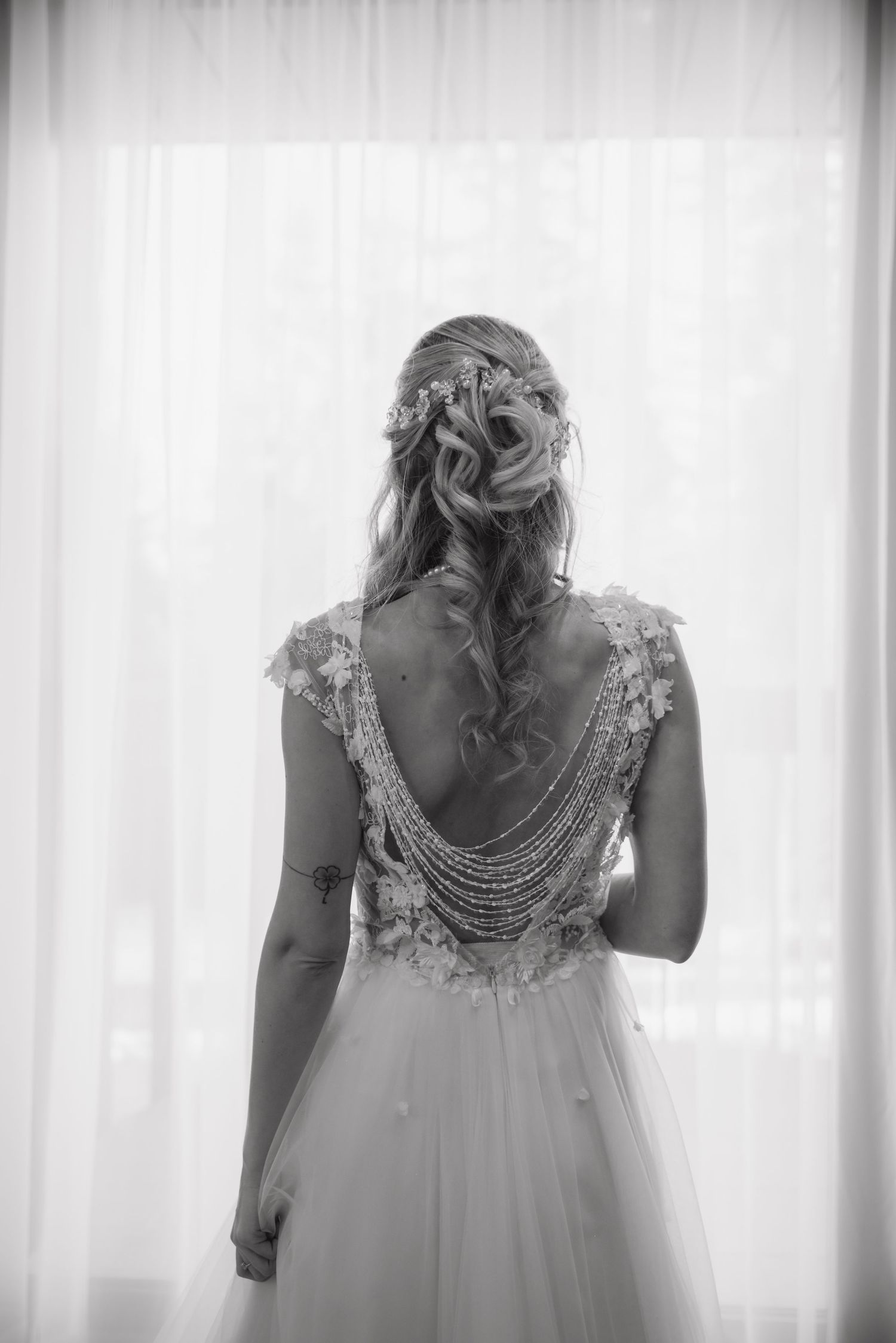 Close-up detail of intricate lace wedding dress back with pearl embellishments.