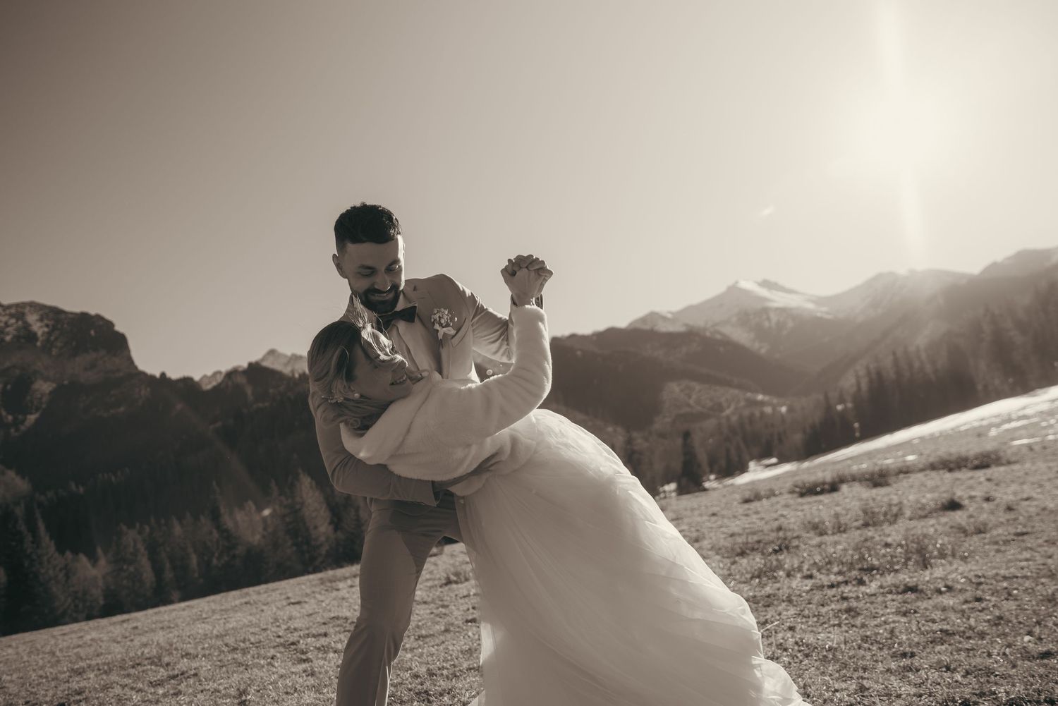 Black and white artistic wedding photography in mountain landscape setting.