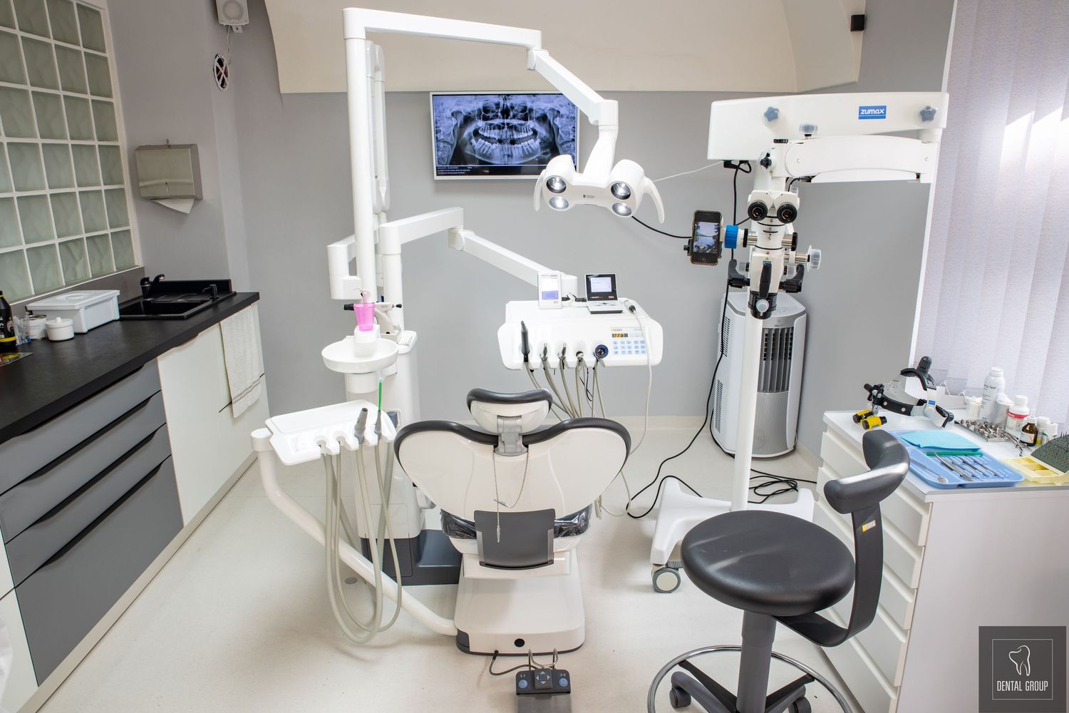 Panoramic view of a pristine dental clinic with multiple treatment stations and modern equipment.
