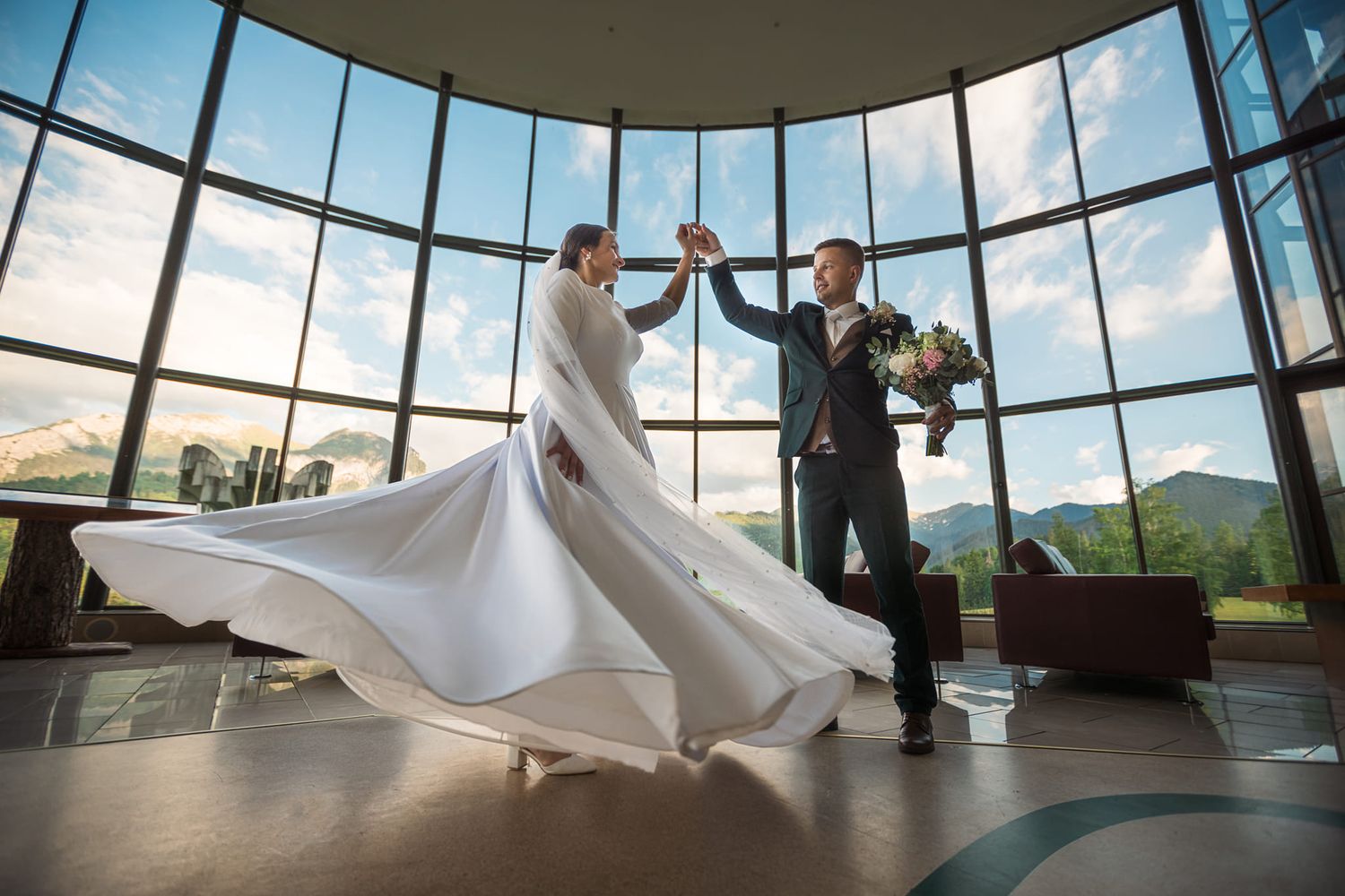 Modern glass-ceiling venue with dramatic wedding dance silhouettes.