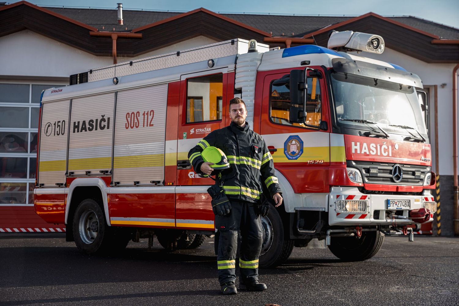 Emergency response vehicles parked in front of a station at dusk.