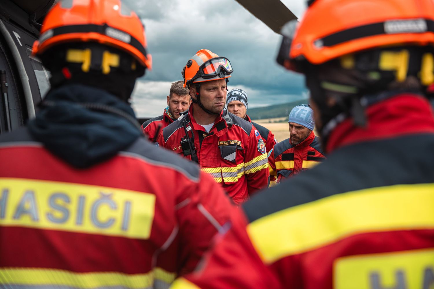 Emergency response team in red uniforms and safety gear coordinating helicopter operations.