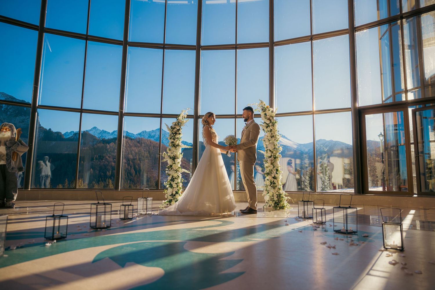 Modern glass-walled venue with panoramic mountain views and curved windows.
