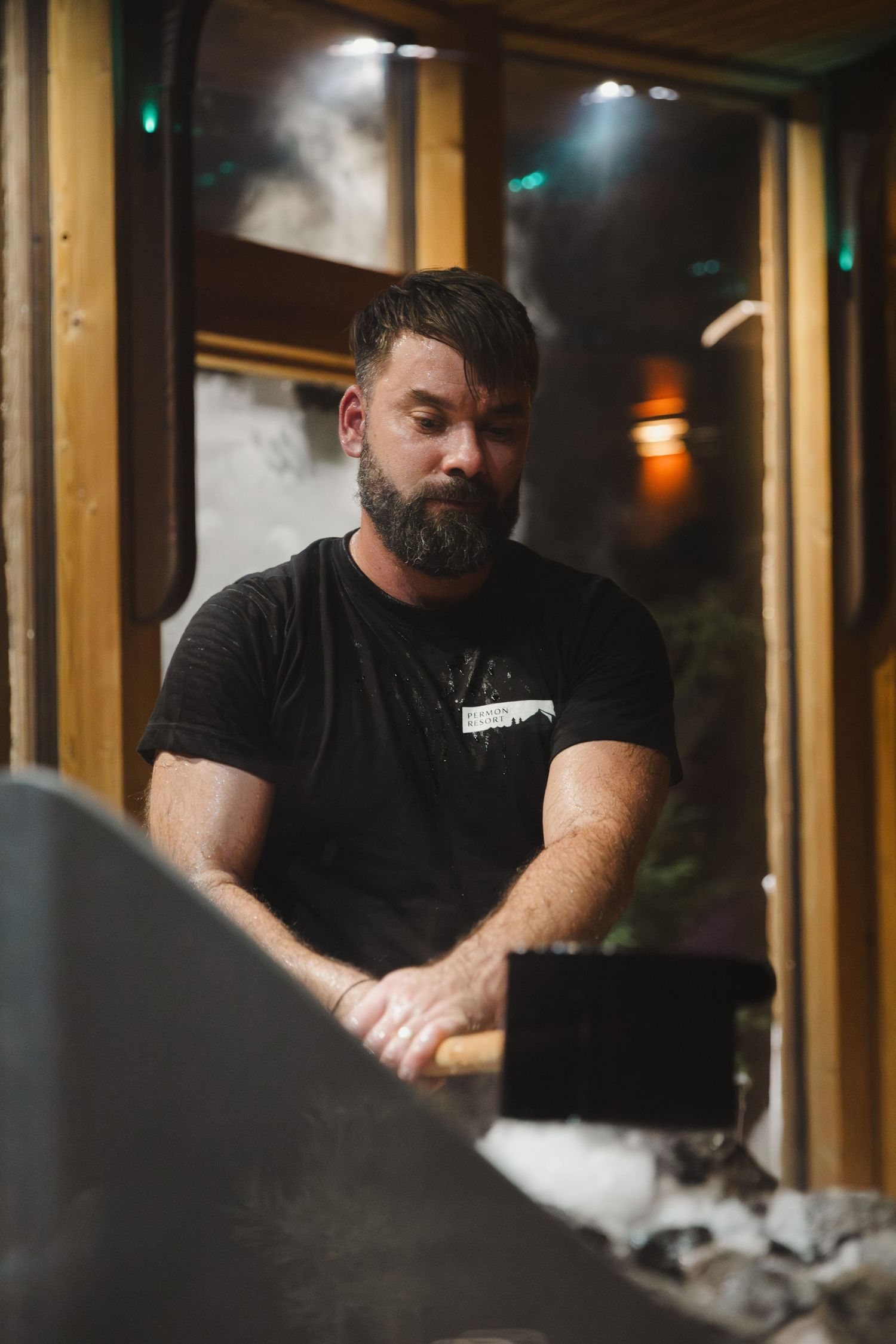 Staff member in black t-shirt working behind counter in dimly lit venue.