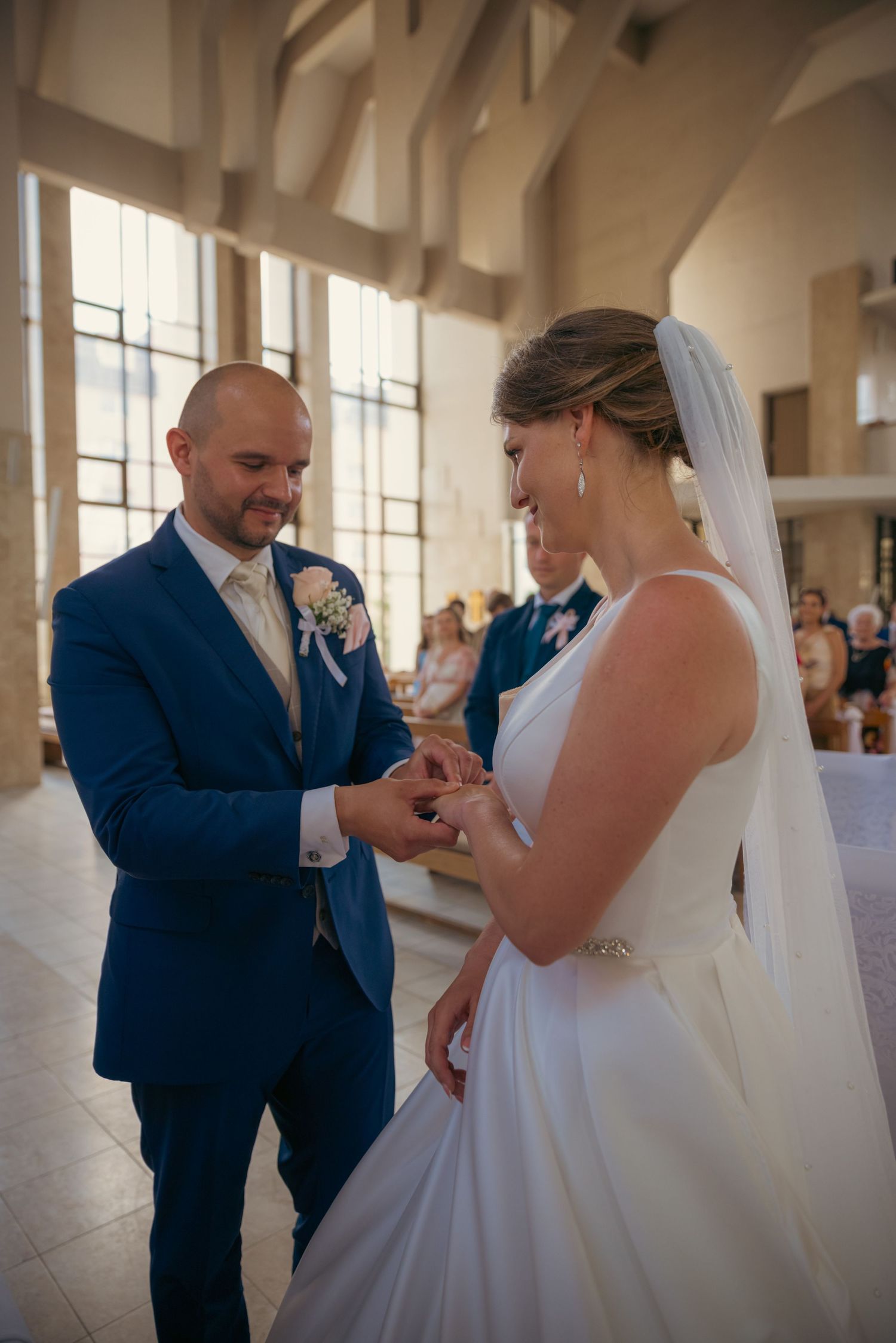 Wedding ceremony taking place in a bright, modern church interior.