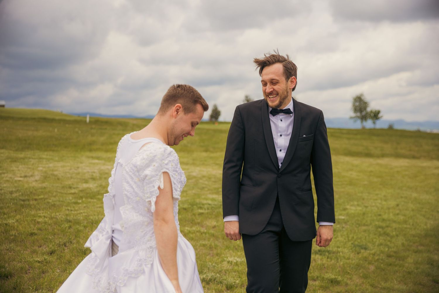 Wedding couple sharing a joyful moment together in an open field.