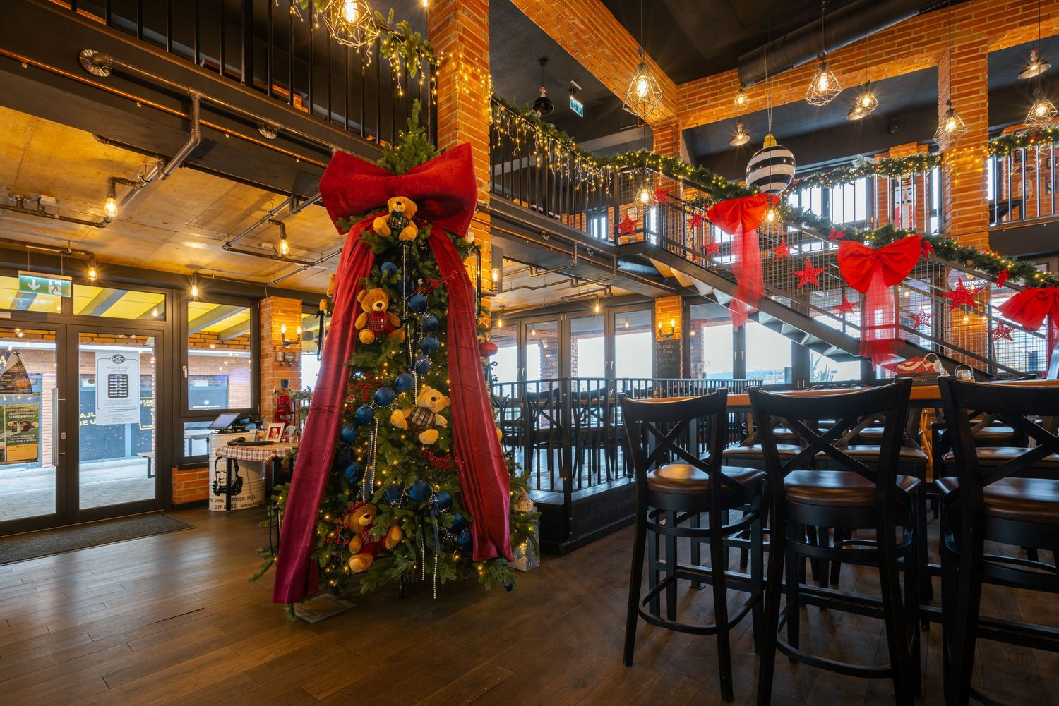 Panoramic view of a restaurant dining area with festive holiday decorations and ambient lighting.
