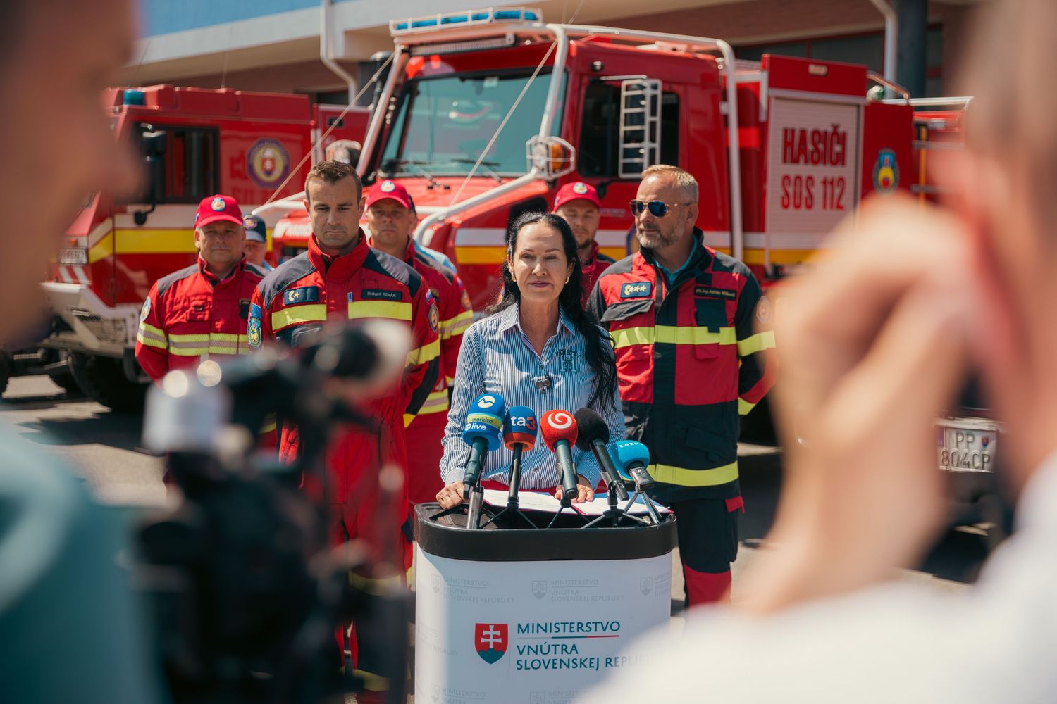 Red fire trucks lined up at a fire station during a public demonstration event.