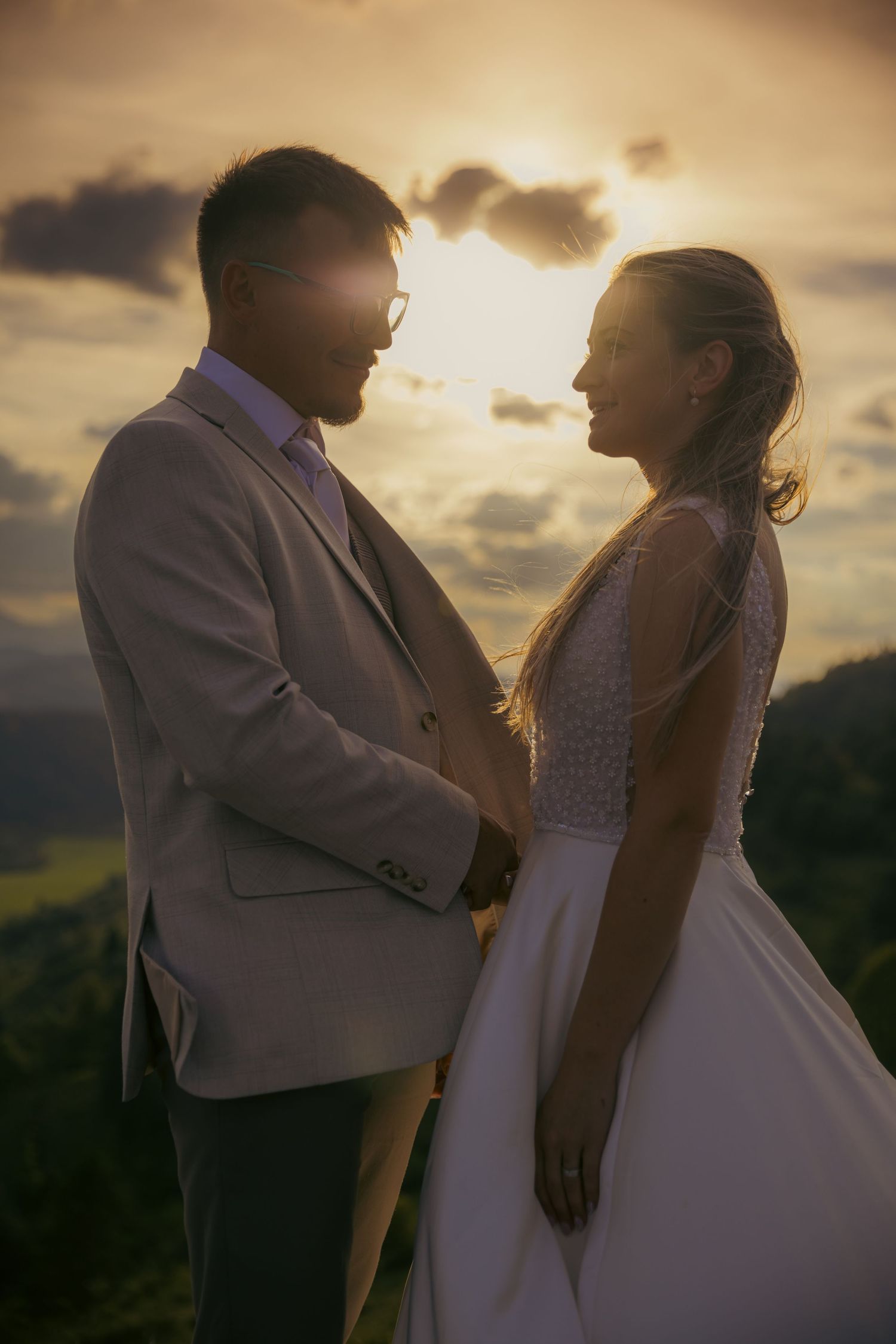 A romantic silhouette of a couple embracing during golden hour with mountains in background.