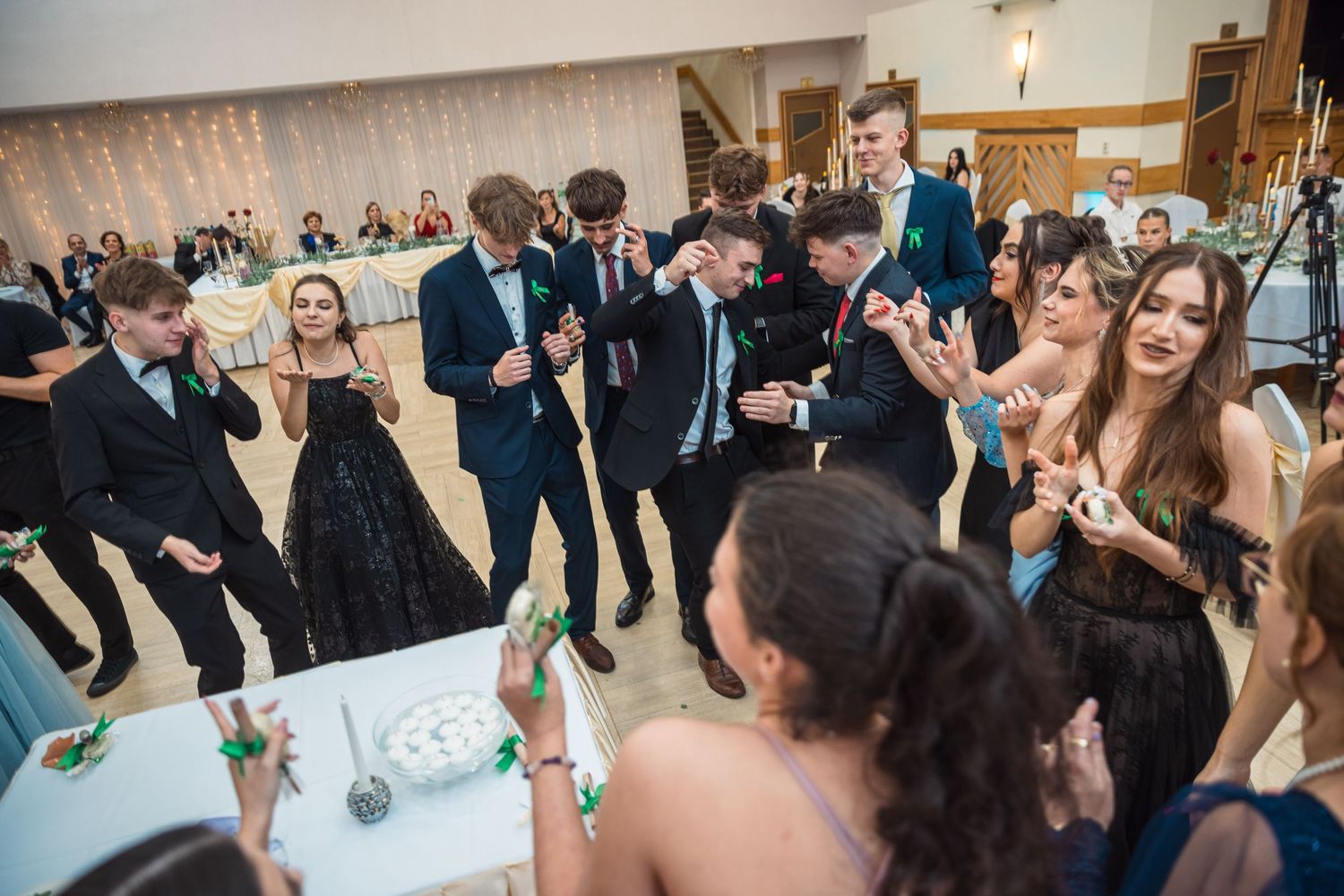 Crowd of party guests dancing and celebrating in large event space.