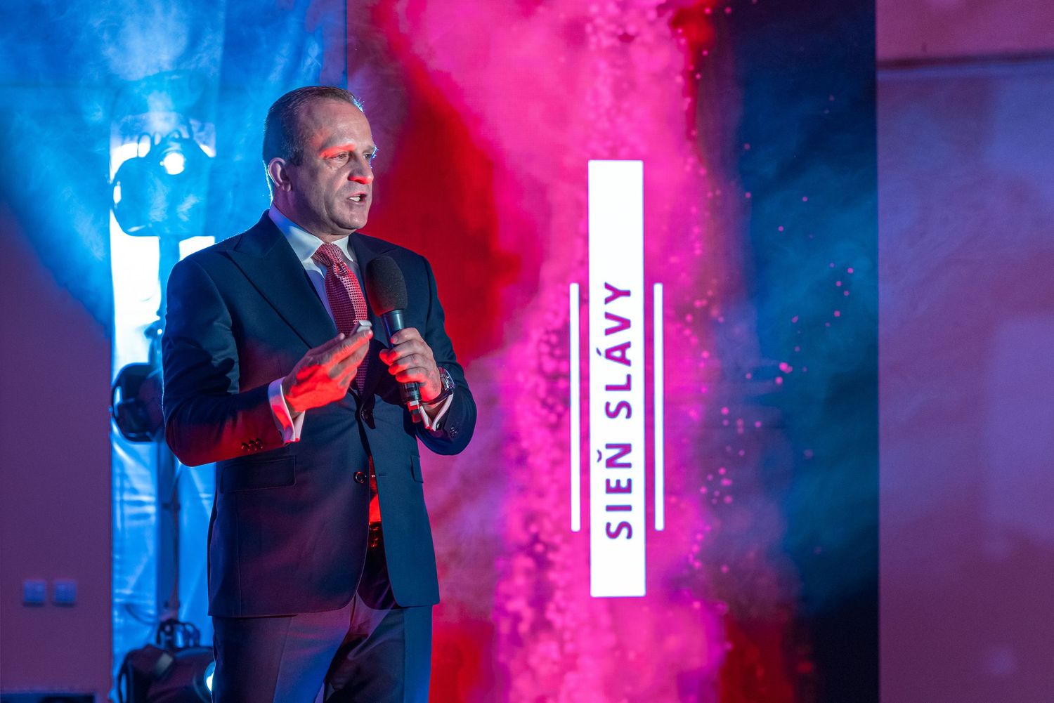 Concert performer on stage with dramatic red and blue lighting effects.