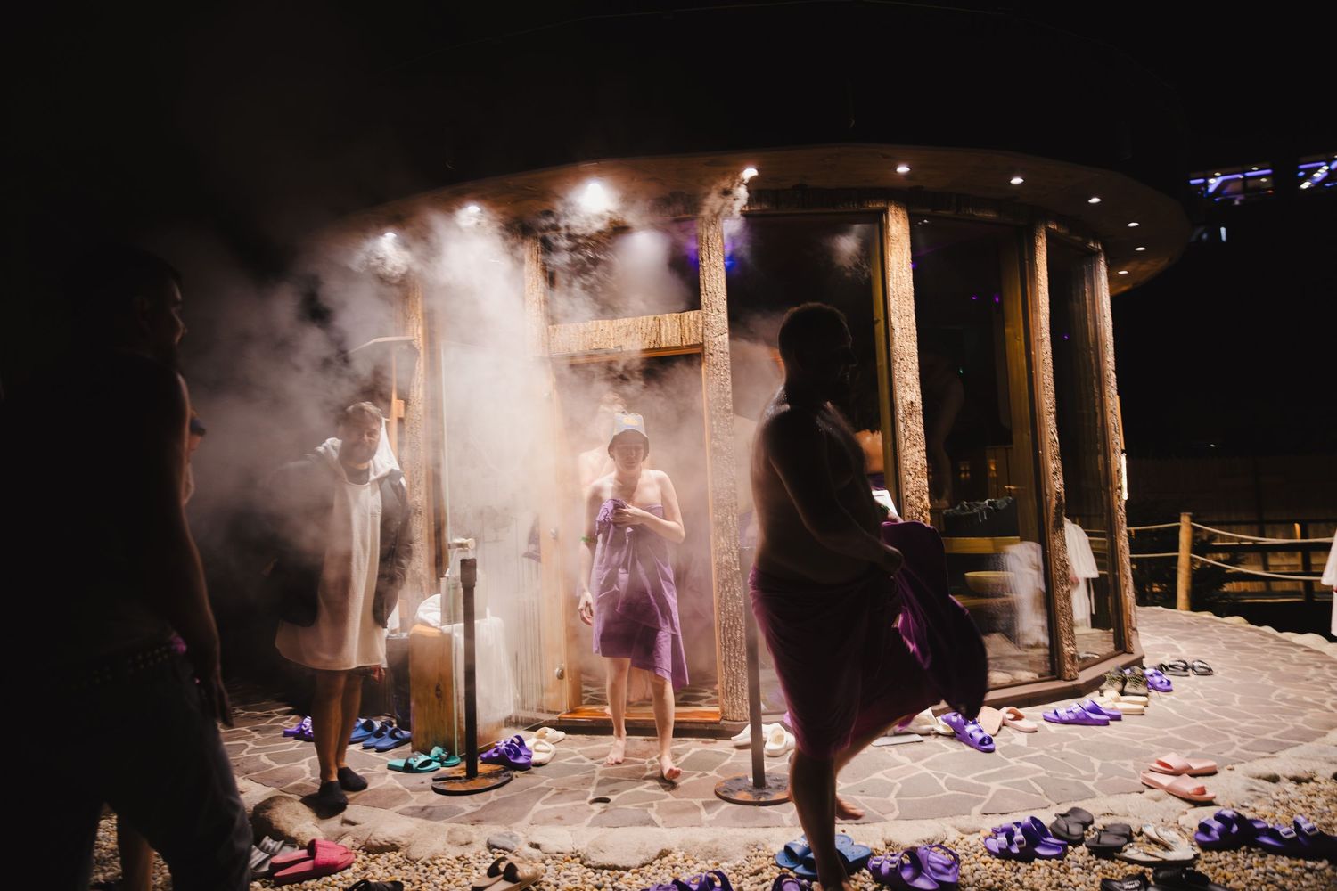 Silhouettes of performers on stage with dramatic fog and lighting effects during a theatrical production.