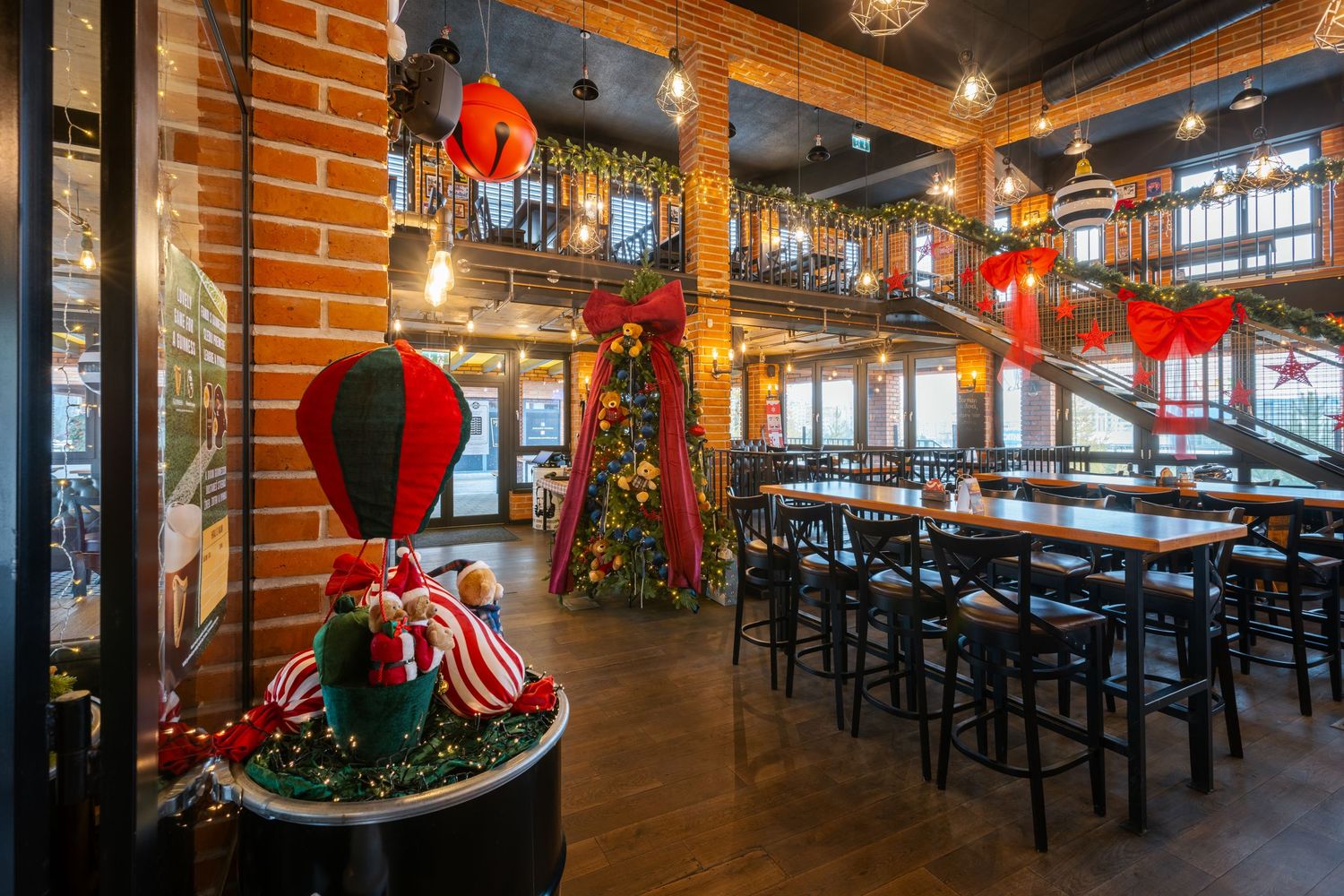 Restaurant interior decorated for Christmas with red bows and holiday greenery.
