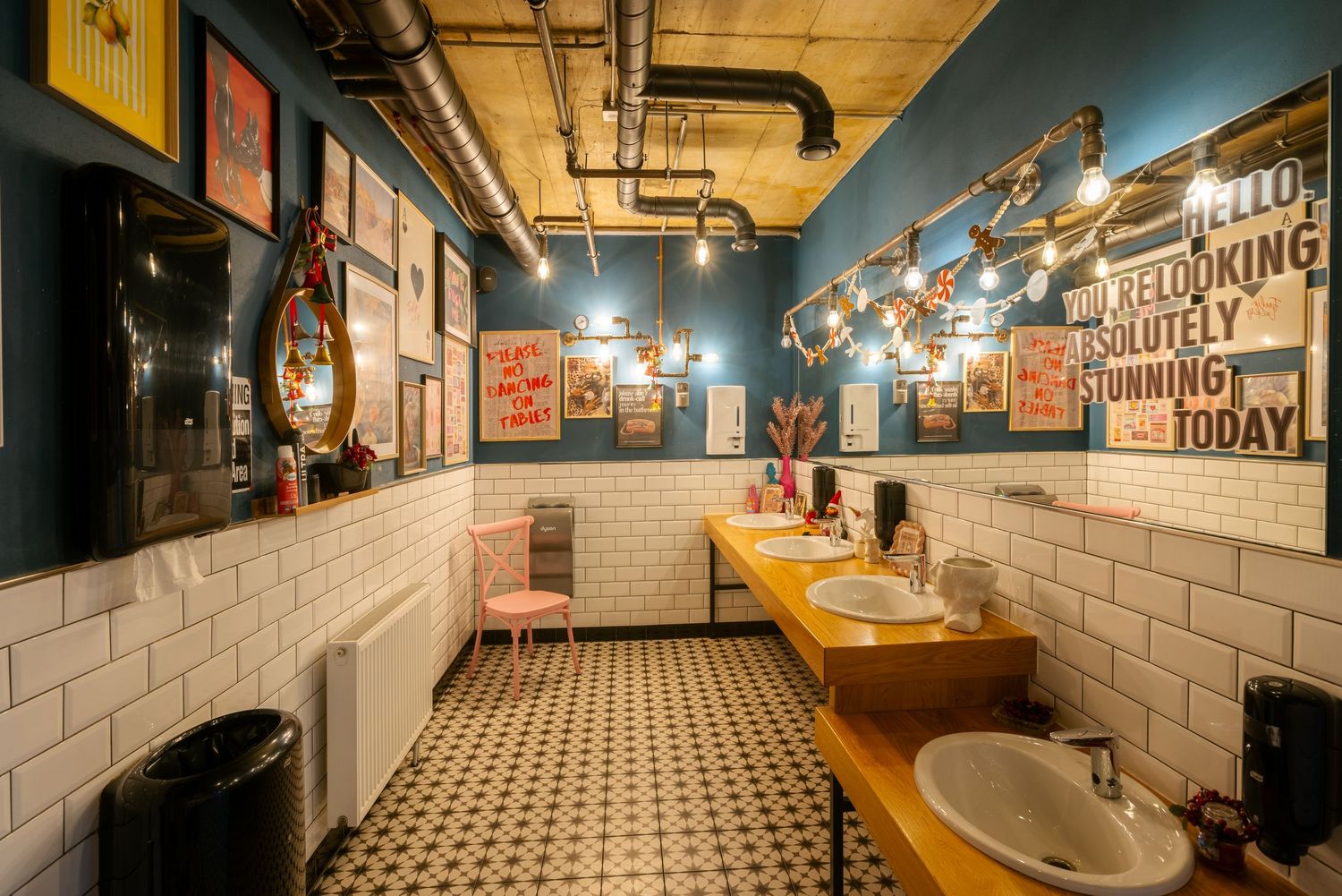Industrial-style restaurant interior with exposed ceiling and white brick walls illuminated by ambient lighting.