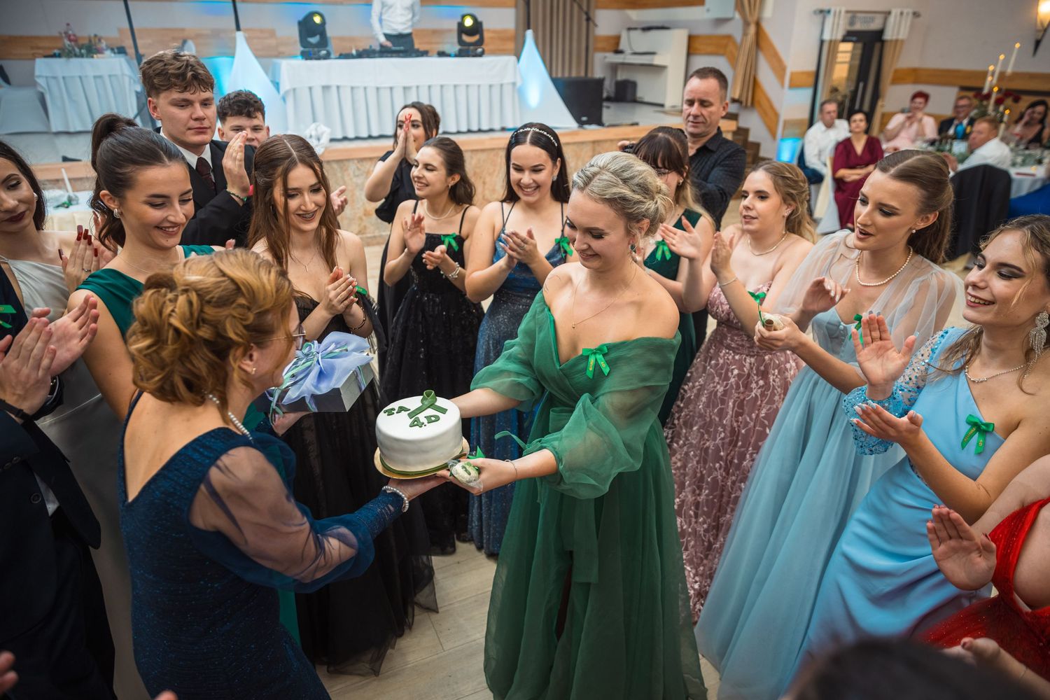 Guests dancing and celebrating at a lively wedding reception with colorful dresses and formal attire.