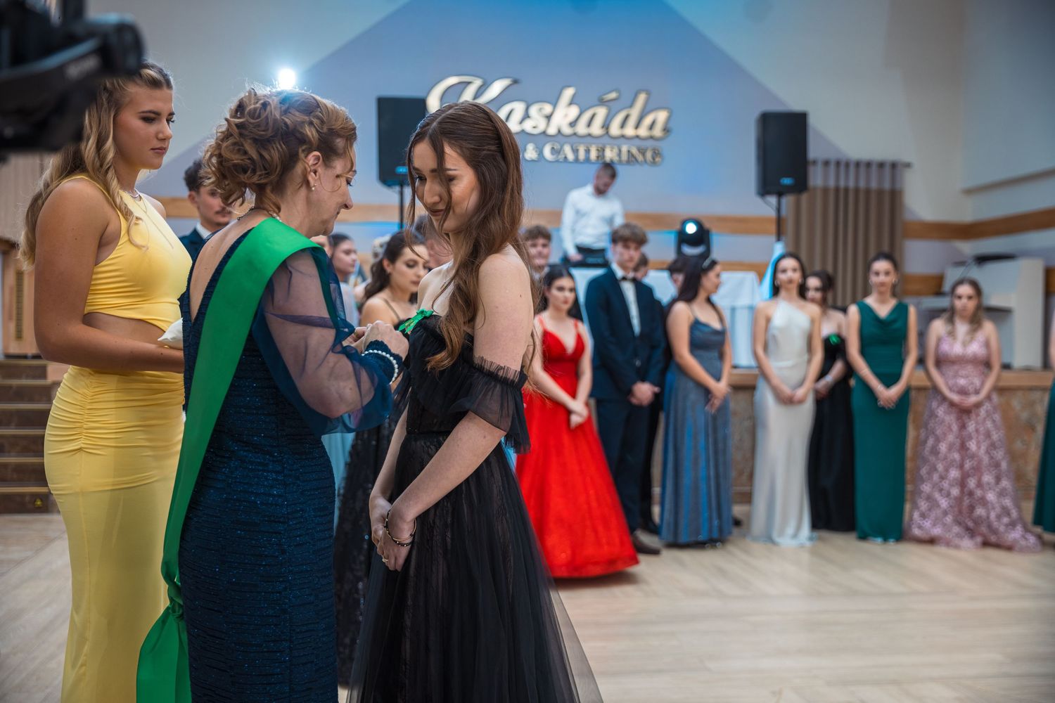 Dancers in formal evening wear gathered at an elegant ballroom event.